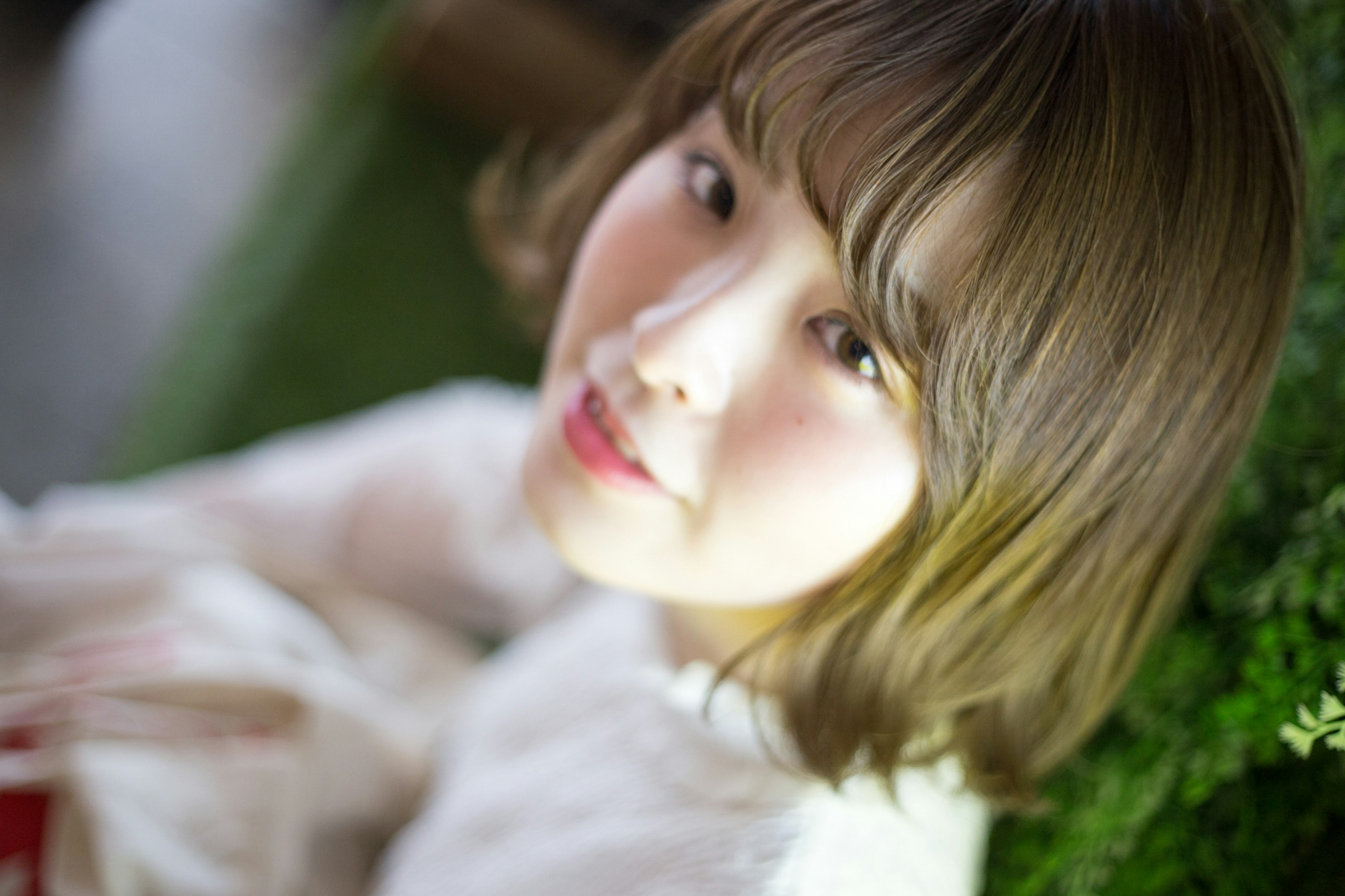 A young woman smiling with a soft light and green background