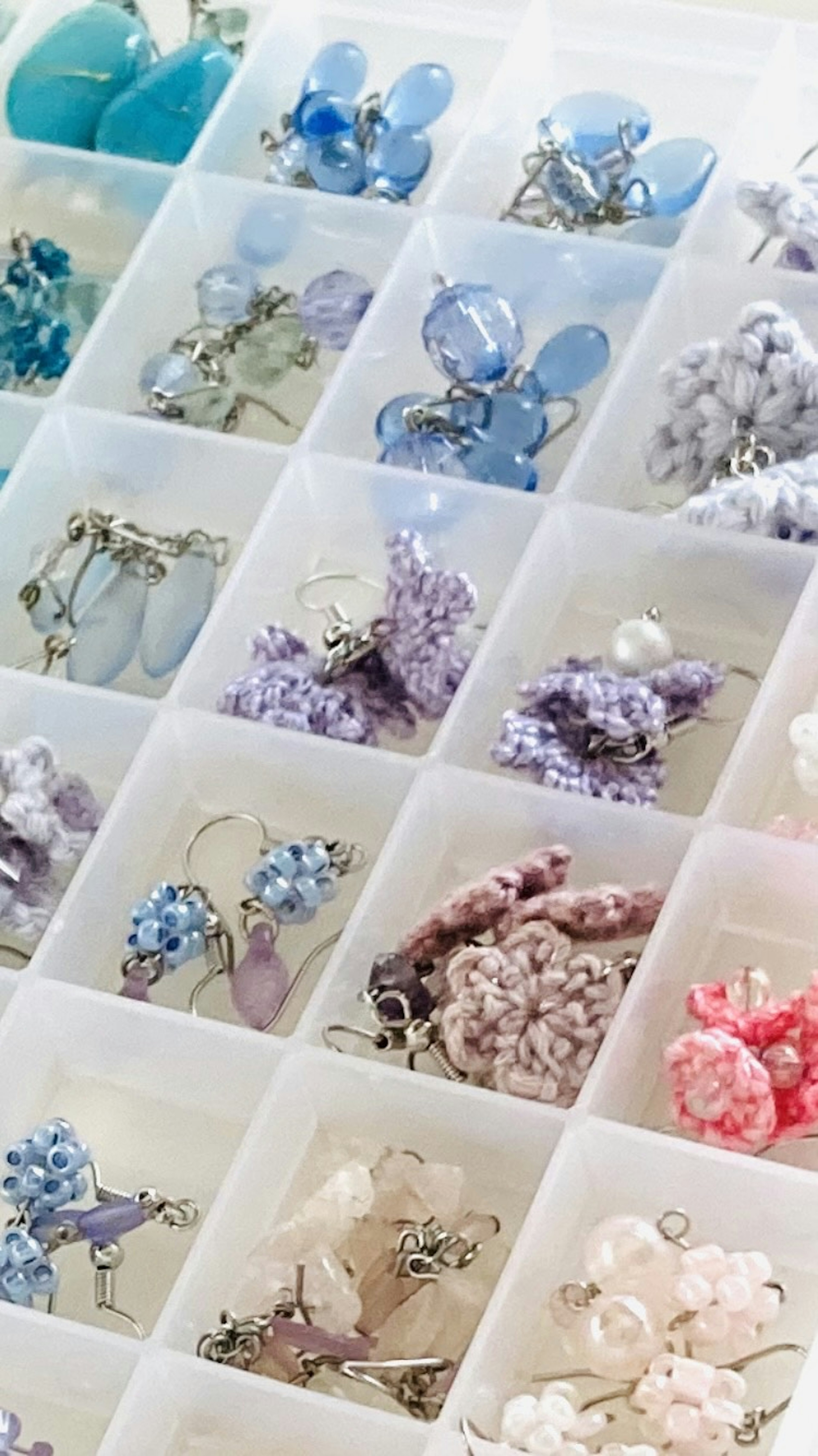 A transparent storage box neatly arranged with colorful earrings