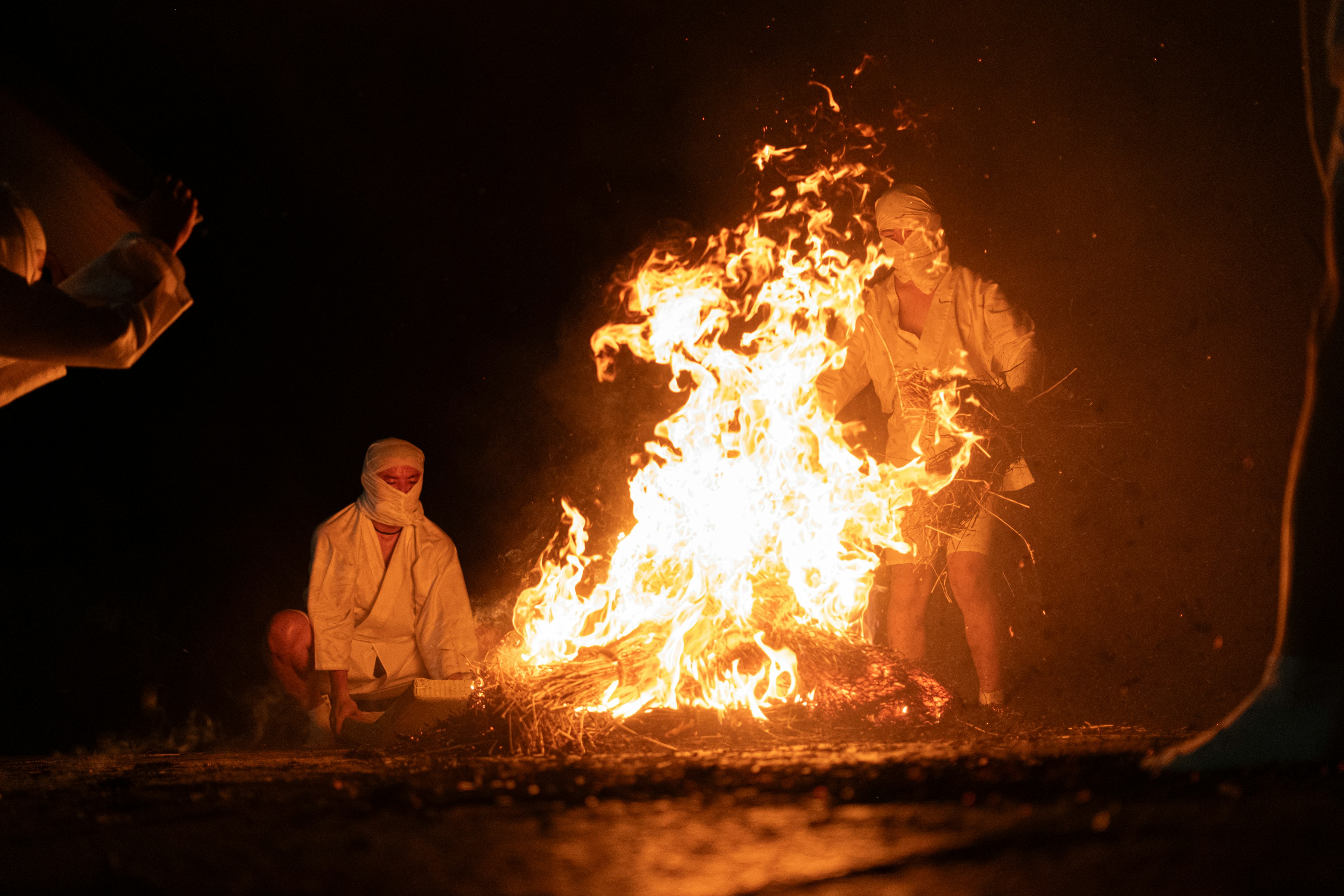 Menschen, die nachts um ein Lagerfeuer sitzen