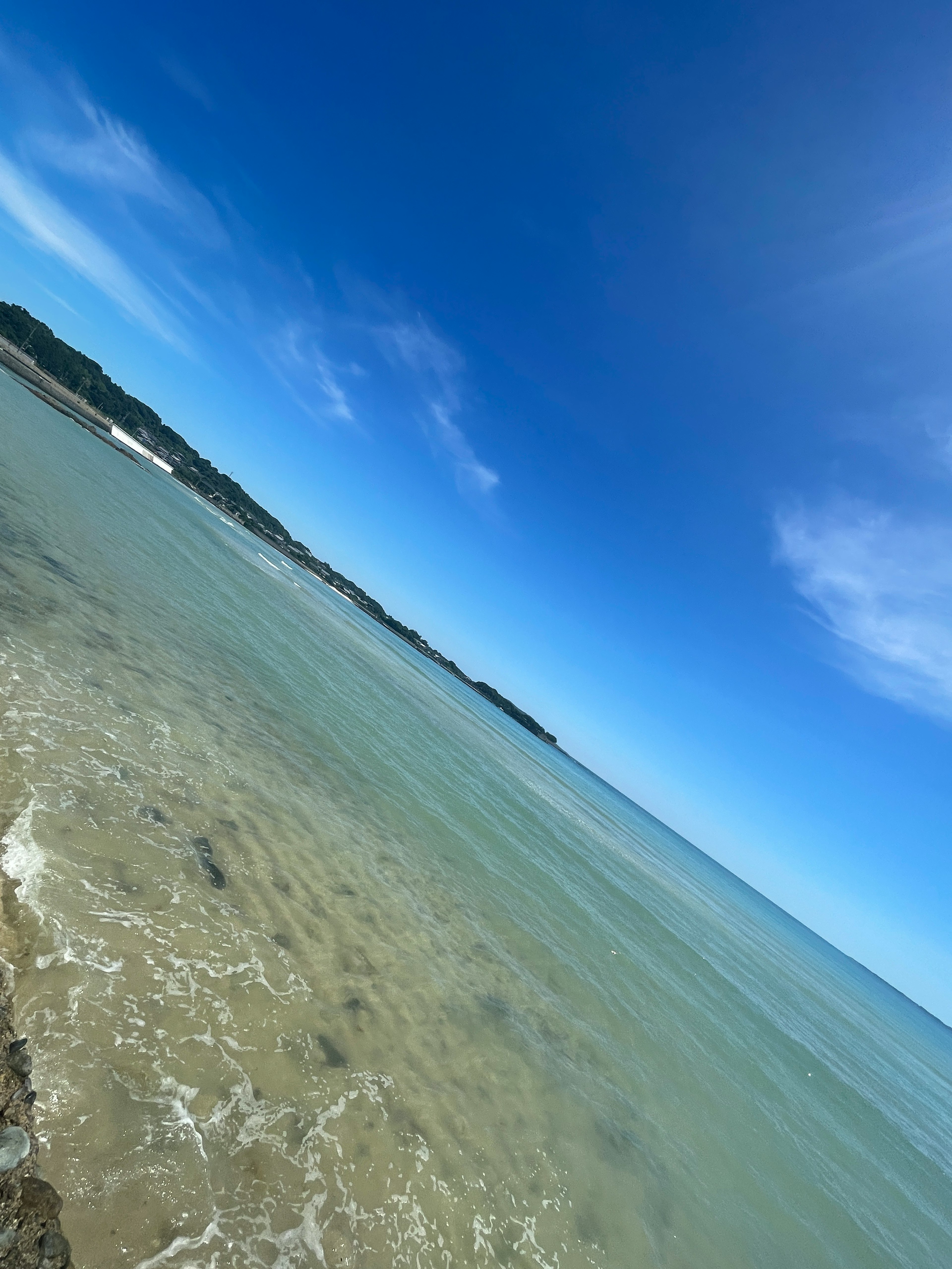 Scenic view of a clear blue sky and transparent sea with visible coastline