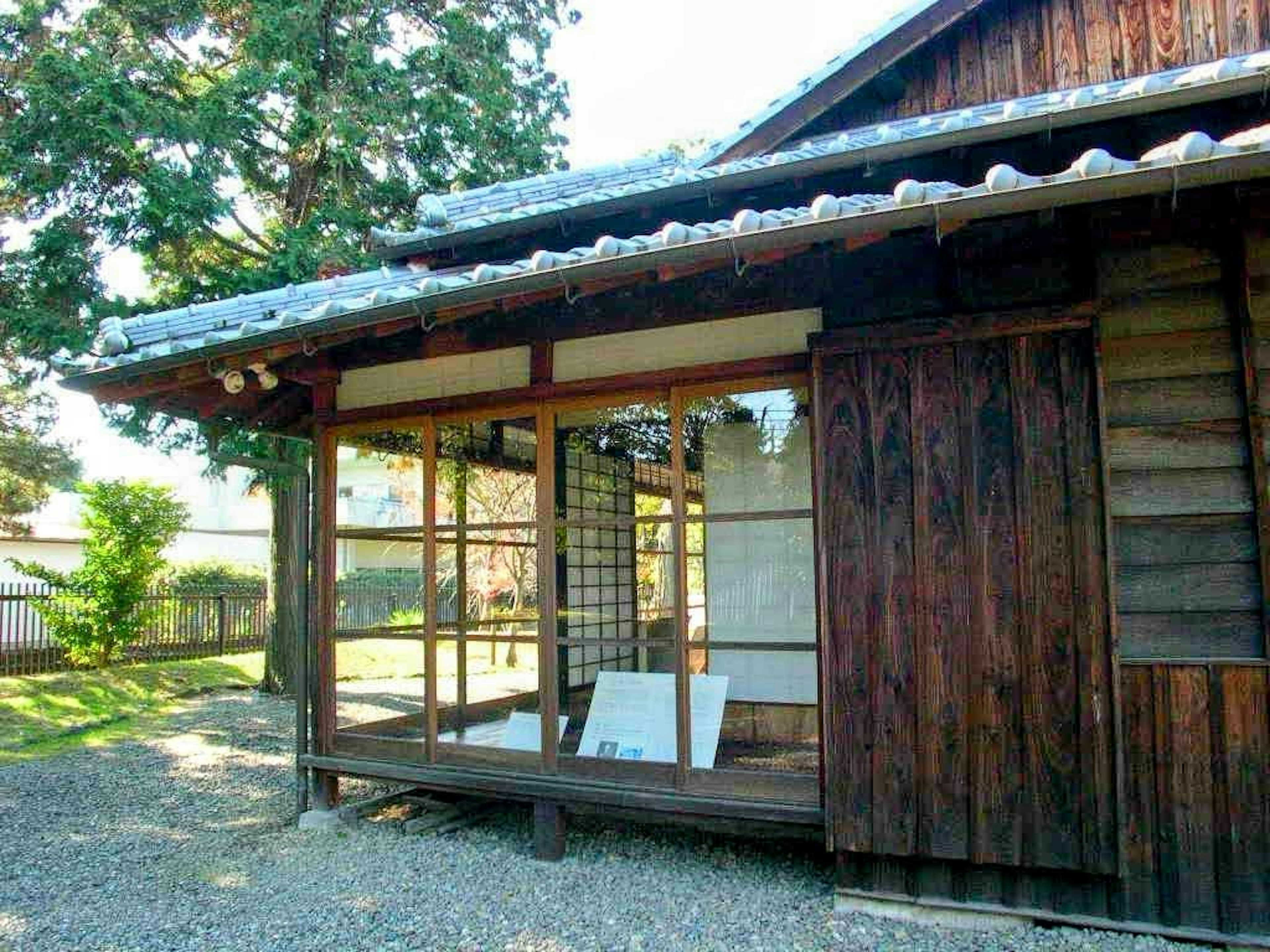 Außenansicht eines traditionellen japanischen Gebäudes mit Holzkonstruktion und grünem Garten