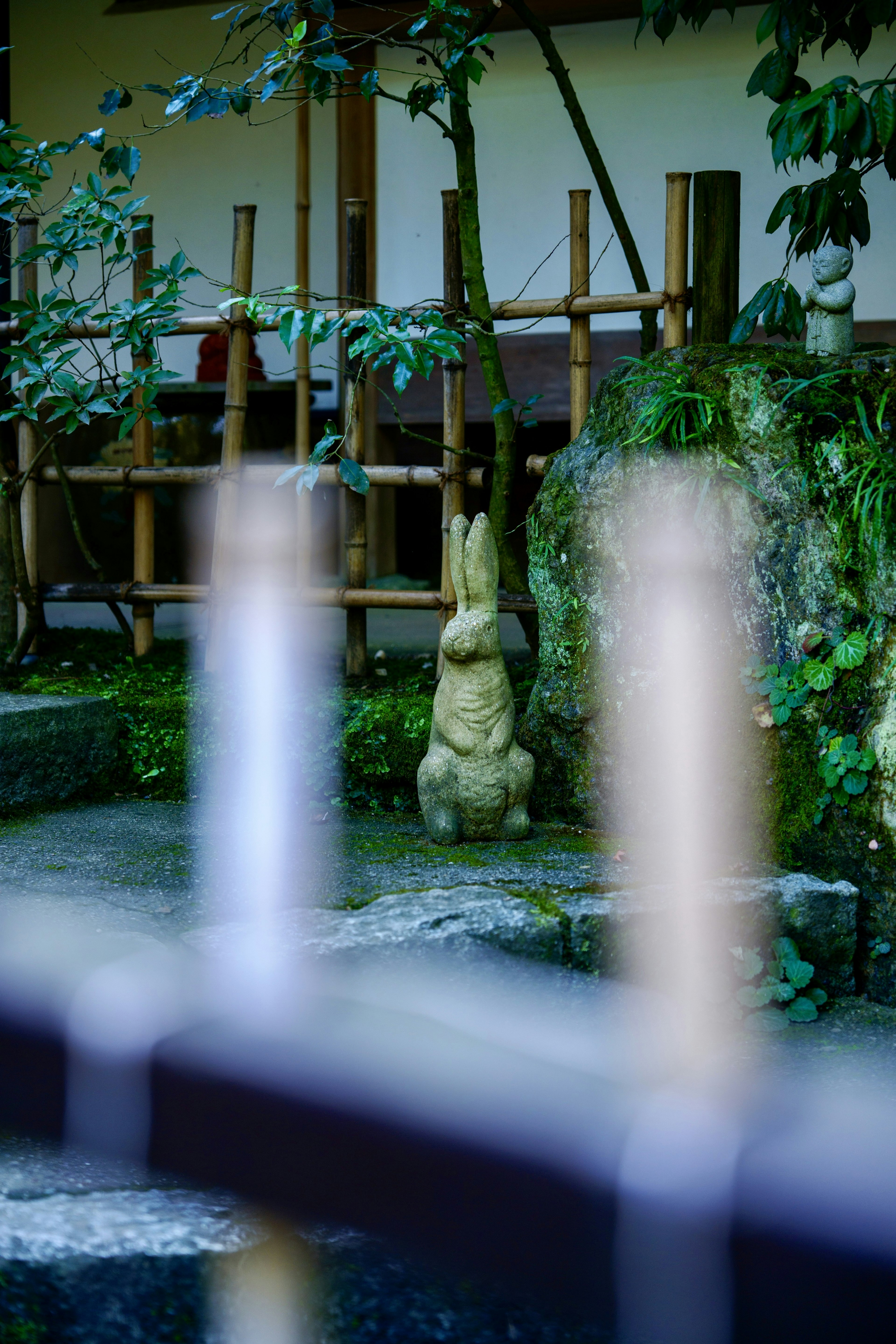 Japanese garden scene featuring a rabbit sculpture and bamboo structures