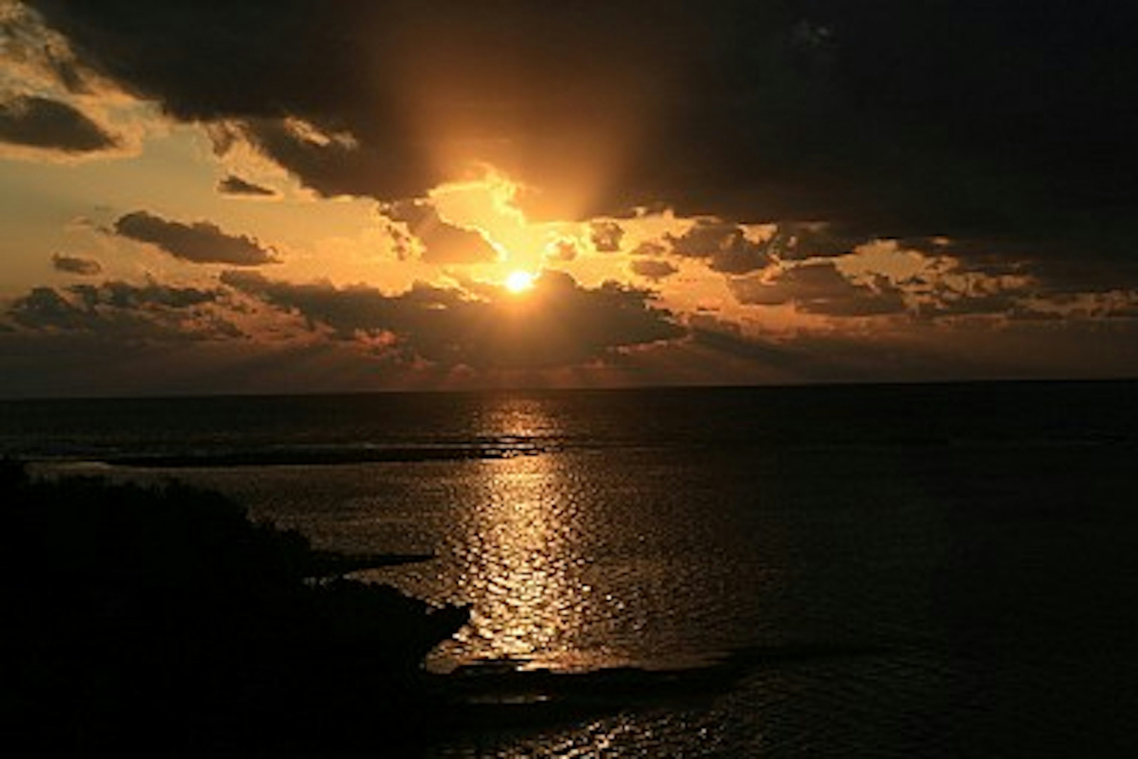 夕日が雲の間から差し込む海の景色