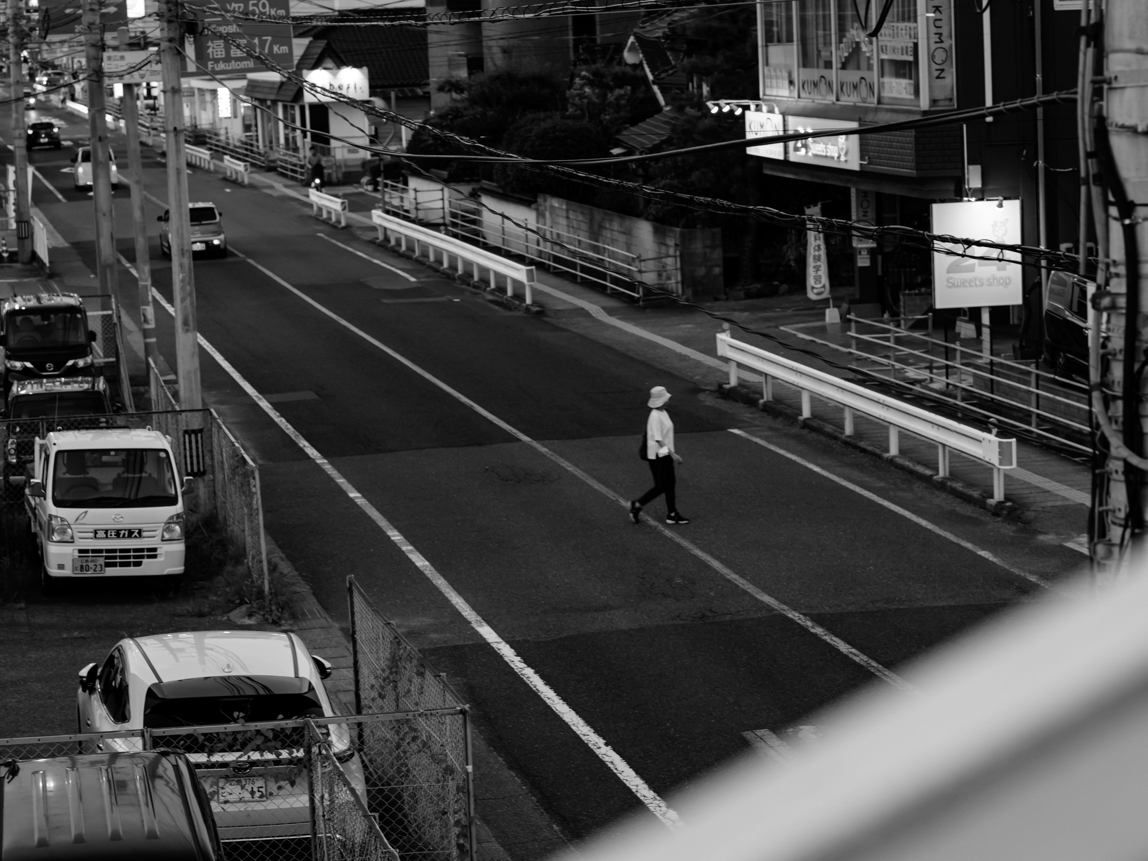 Persona caminando por una carretera en blanco y negro con paisaje circundante