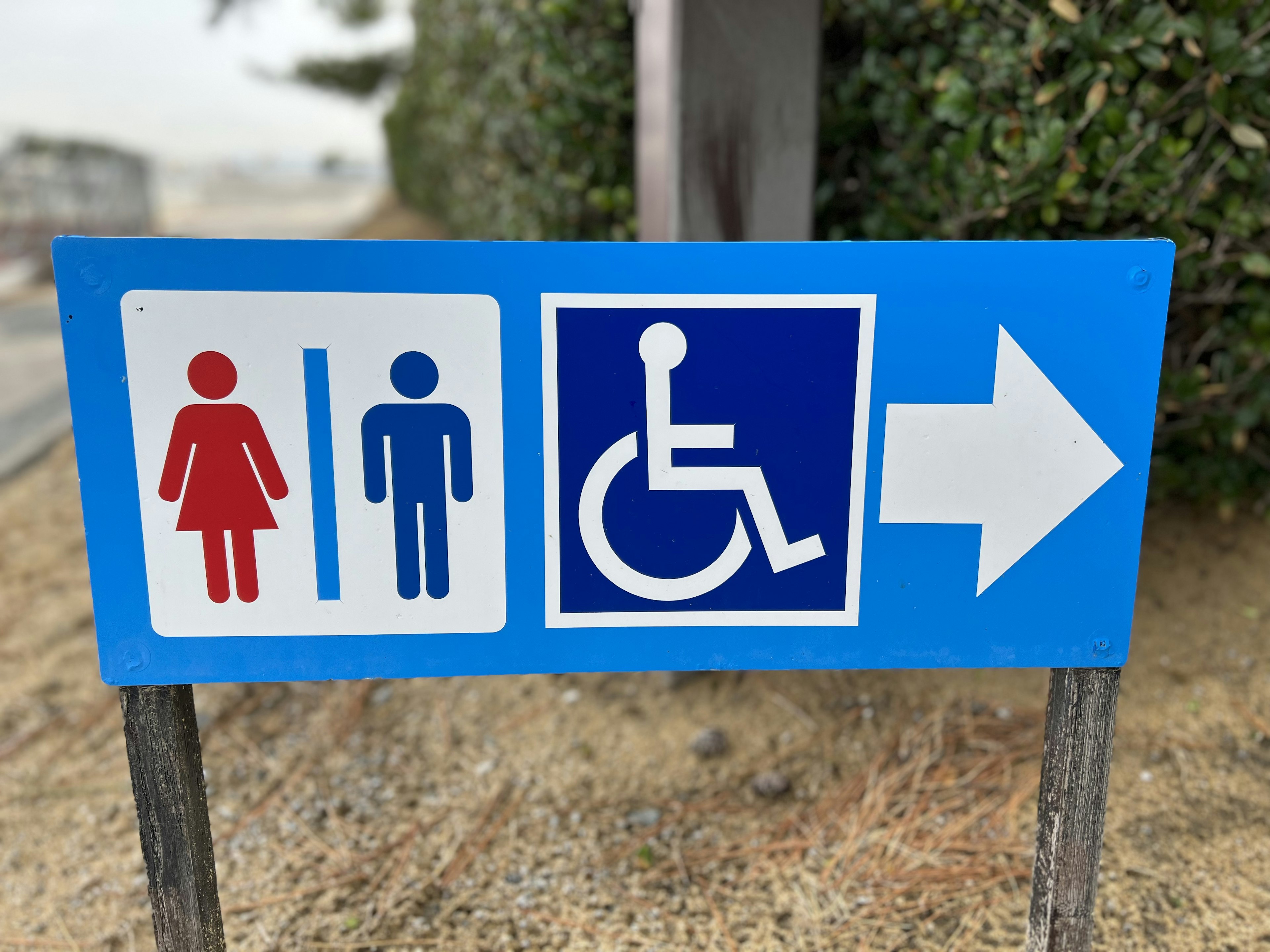 Señal que indica los baños para mujeres y hombres junto con el símbolo de baño accesible