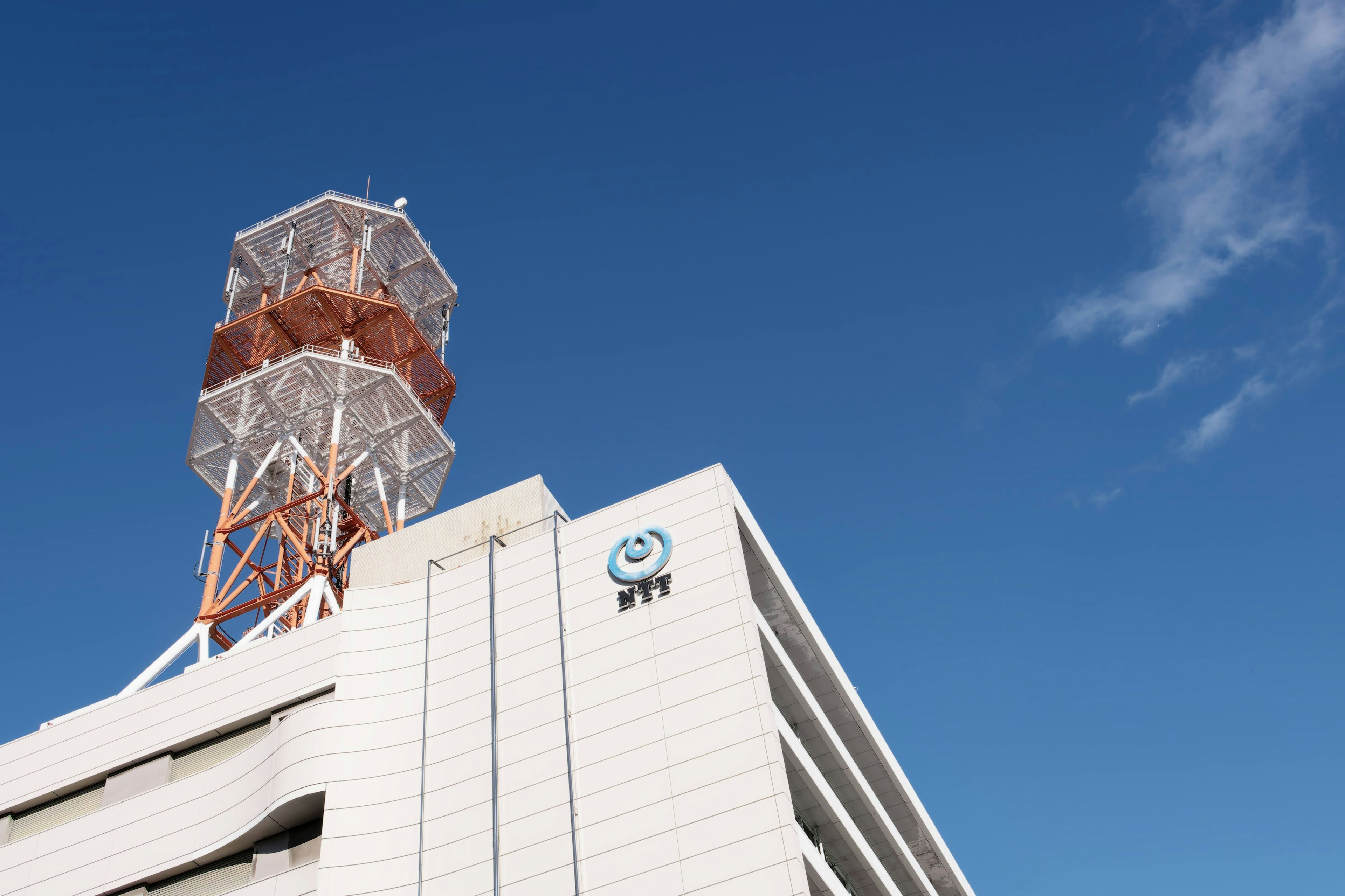 Torre di comunicazione su un edificio bianco sotto un cielo azzurro