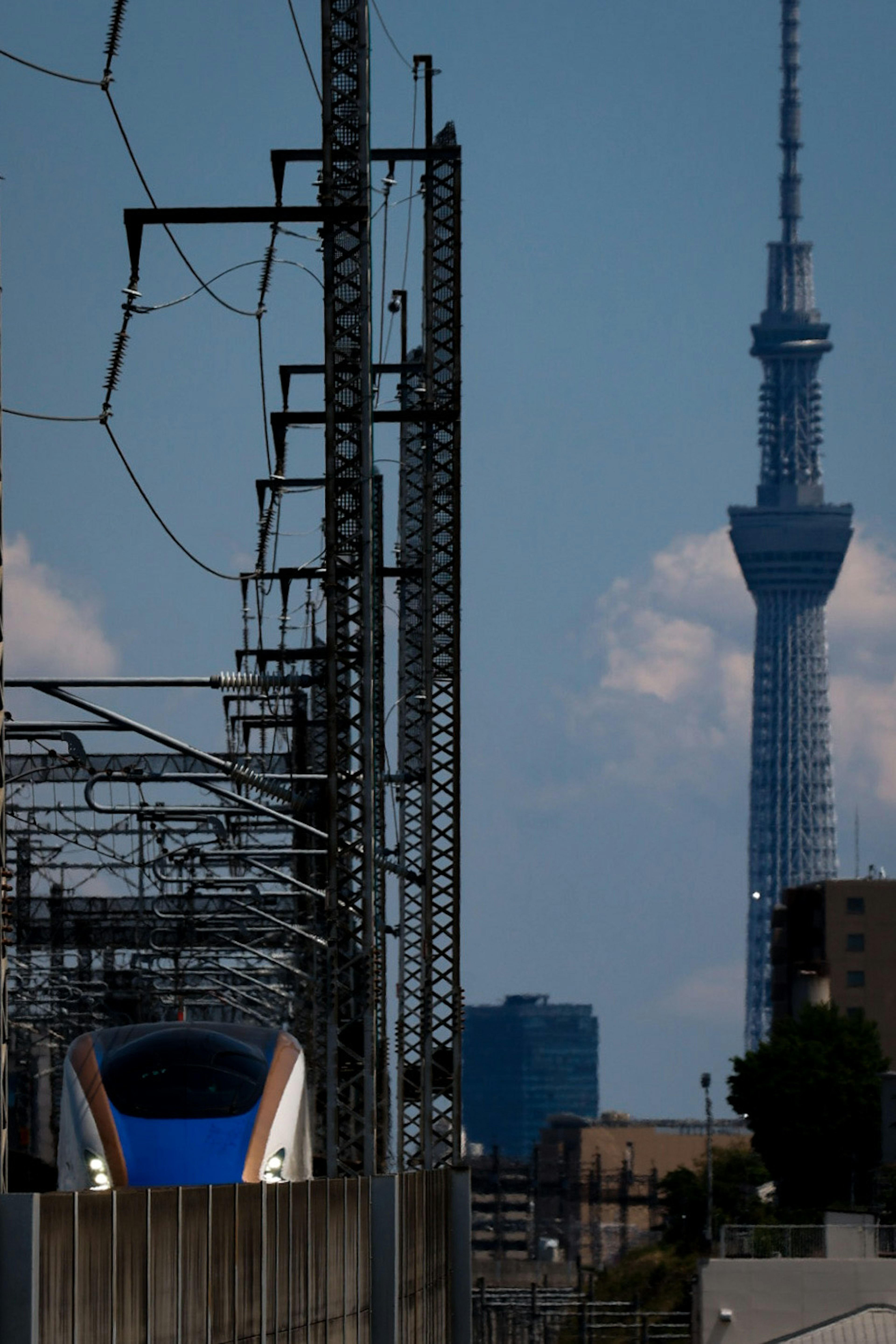 Shinkansen train alongside Tokyo Skytree in the background