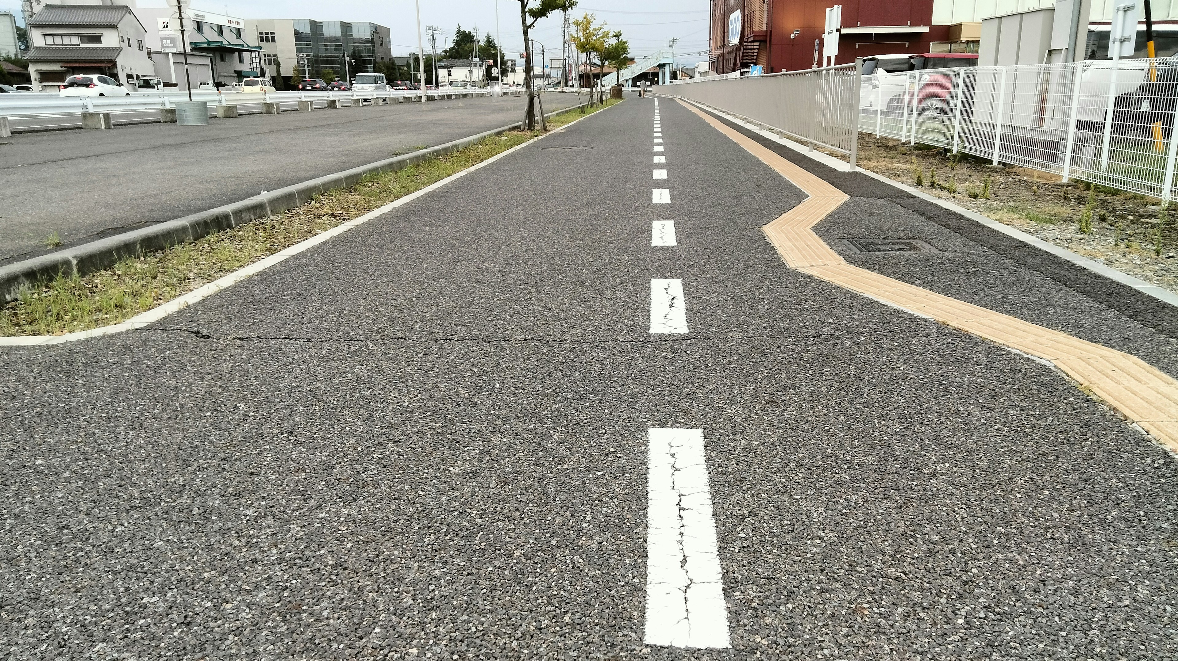 Strada asfaltata con linee bianche e segnaletica arancione