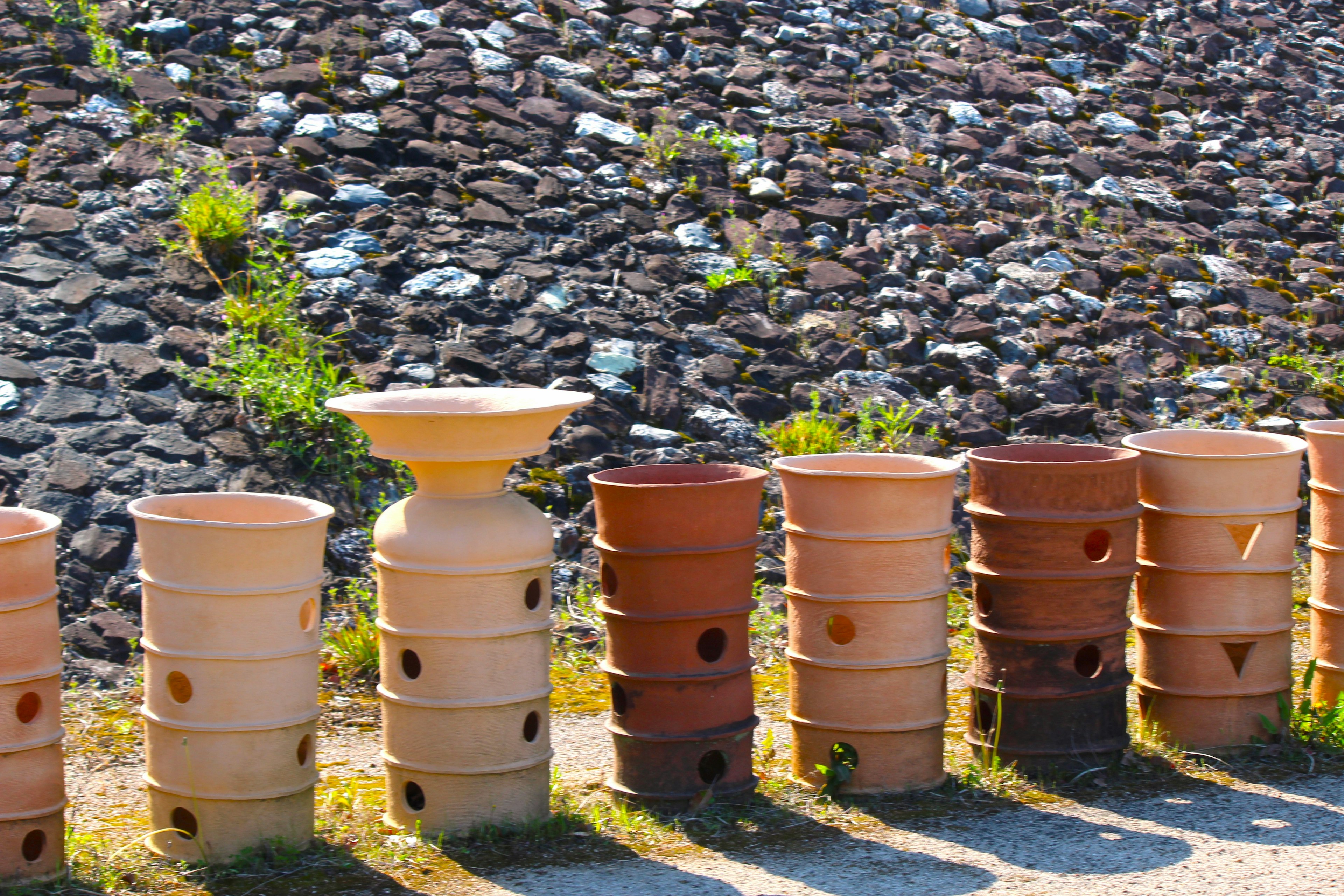 Rangée de pots en terre cuite à côté d'un mur en pierre