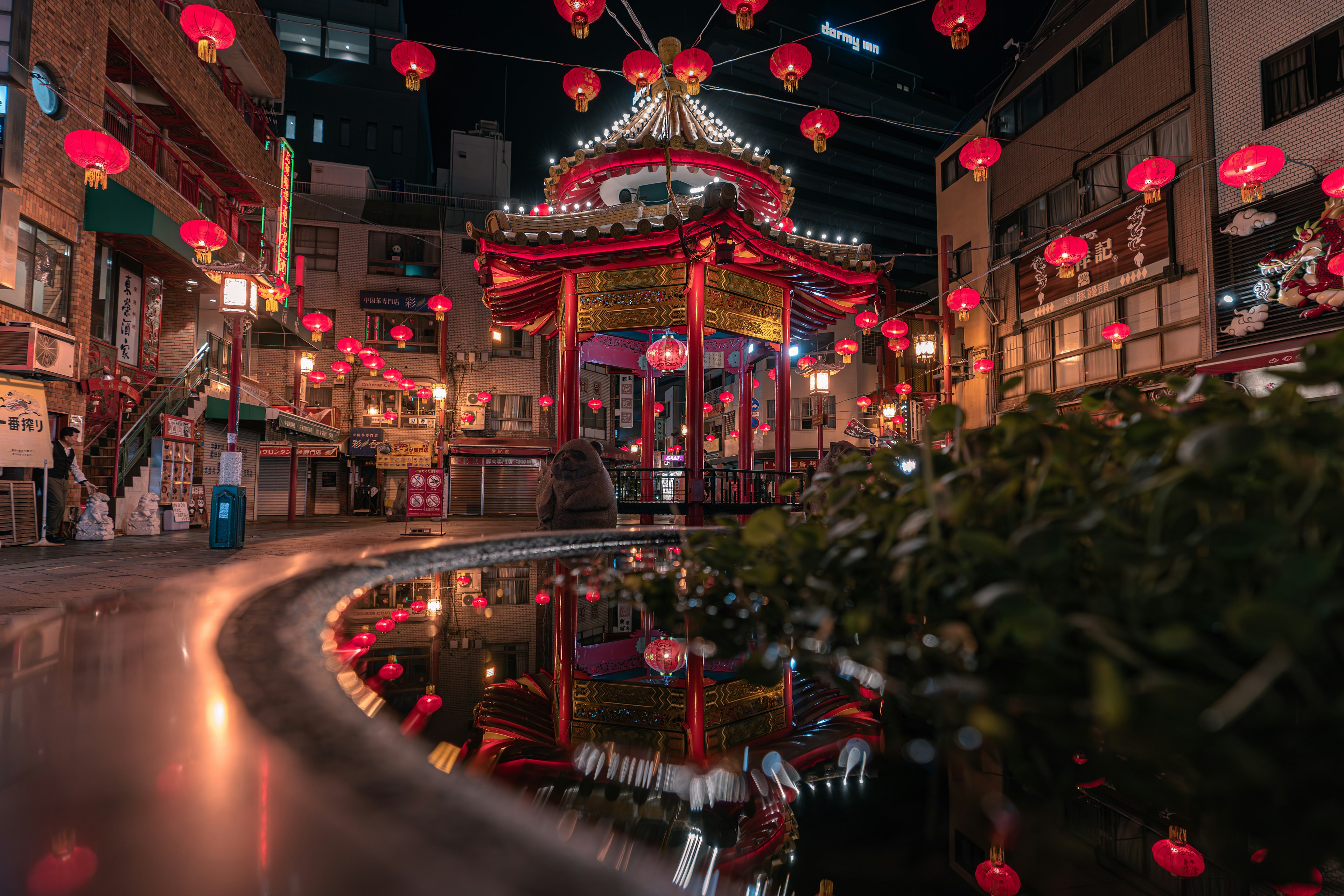 Pemandangan malam Chinatown dengan lentera merah dan refleksi di kolam