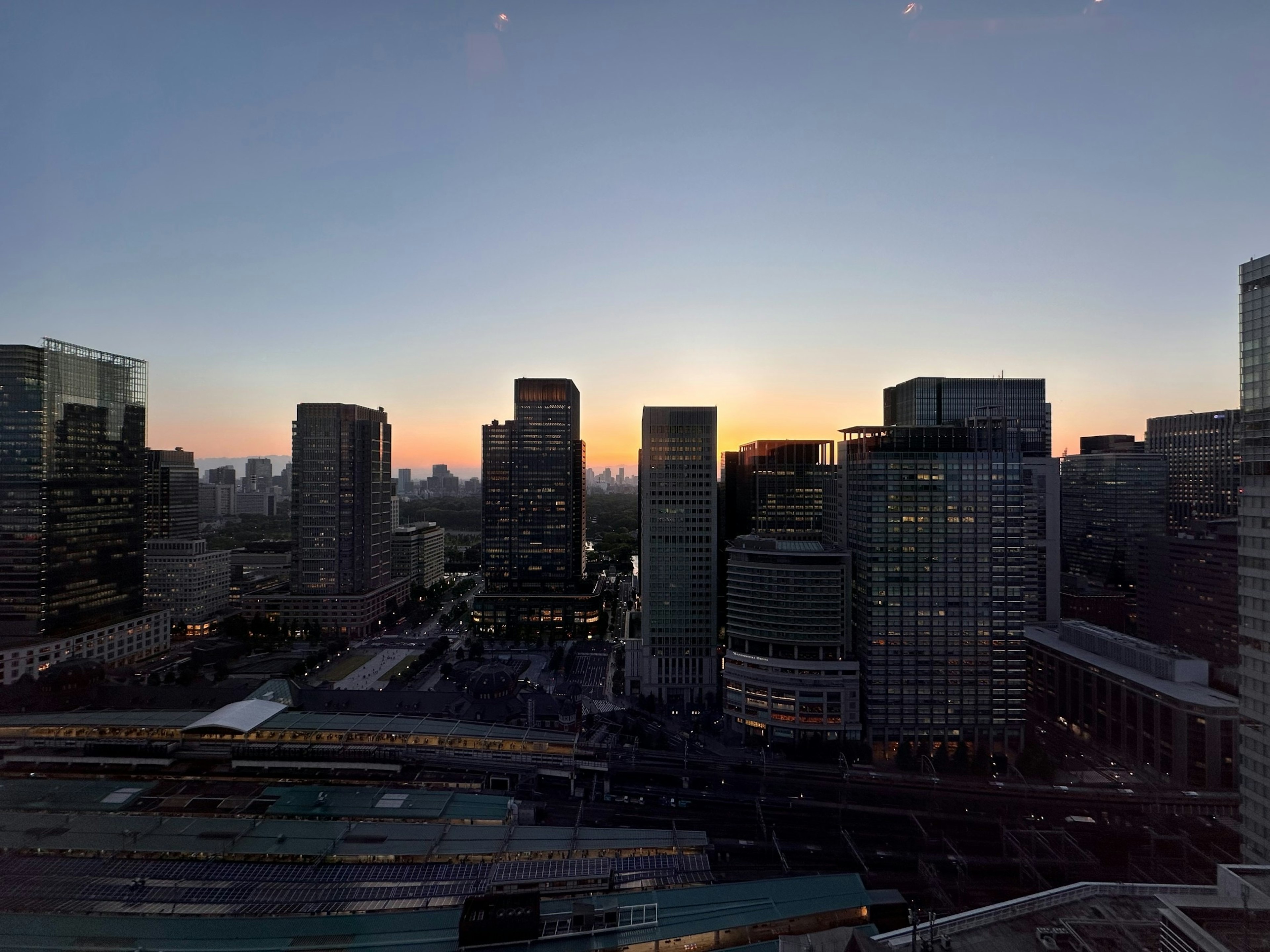 City skyline at sunset with tall buildings and orange sky