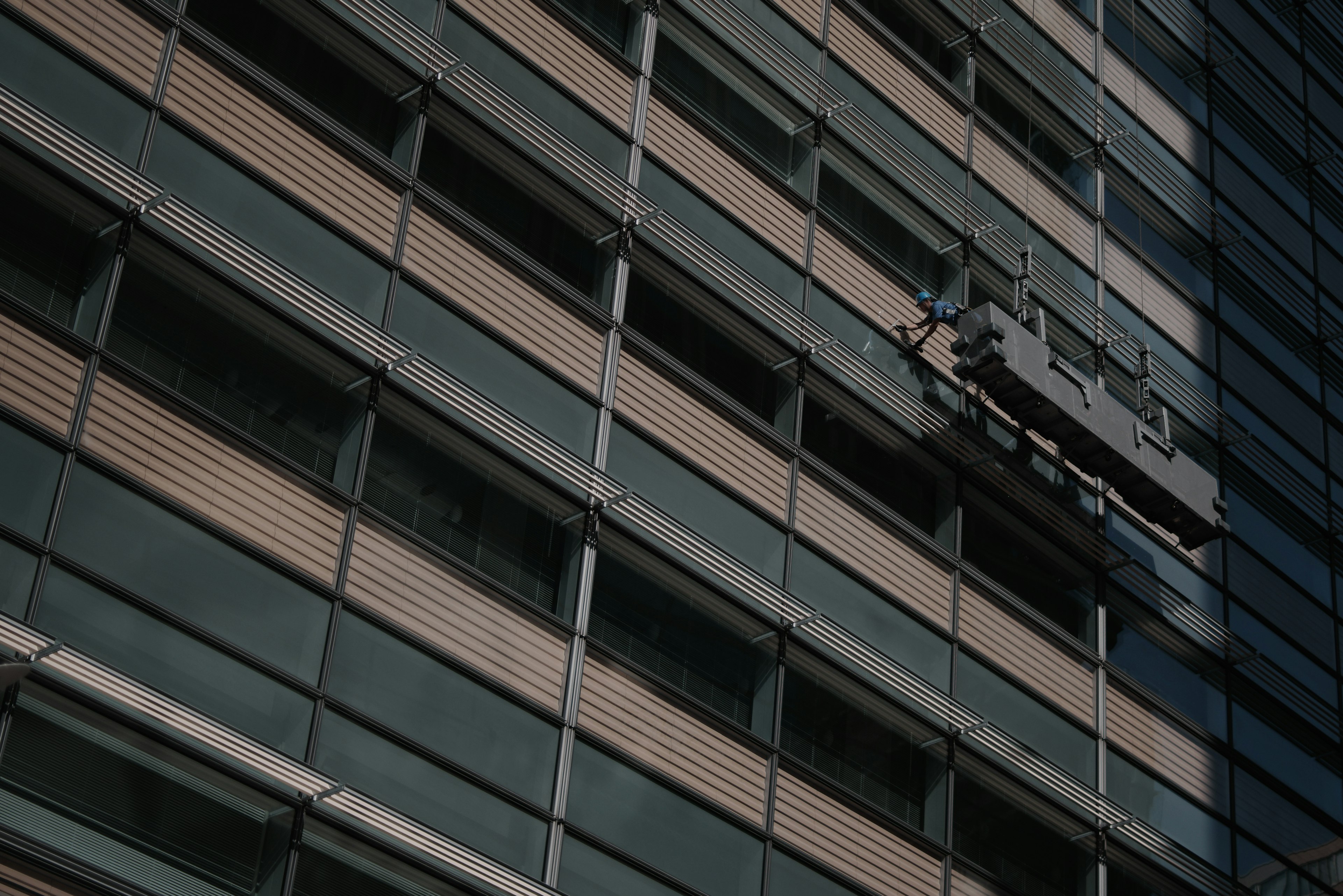 Glass facade of a high-rise building with an external cleaning platform