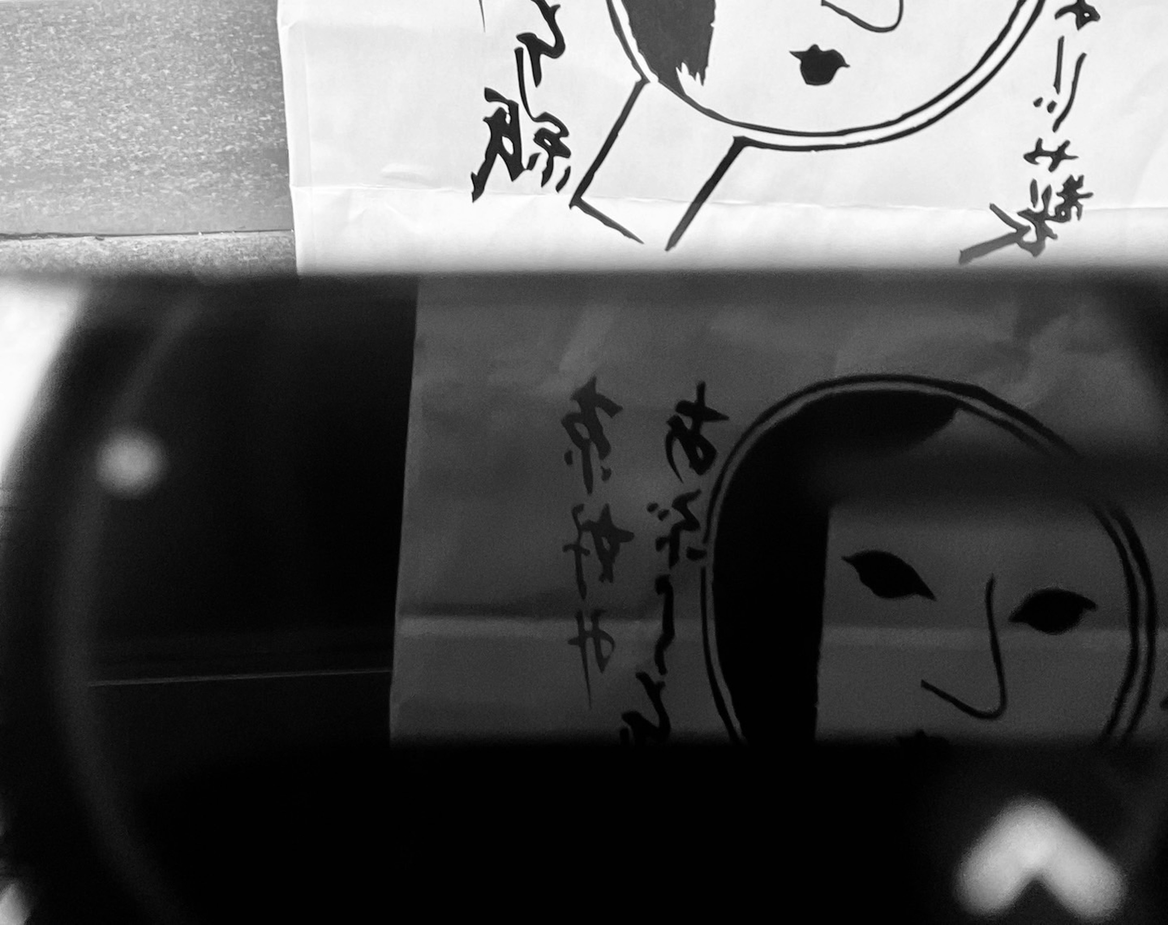 Black and white image featuring traditional Japanese mask and mirror design