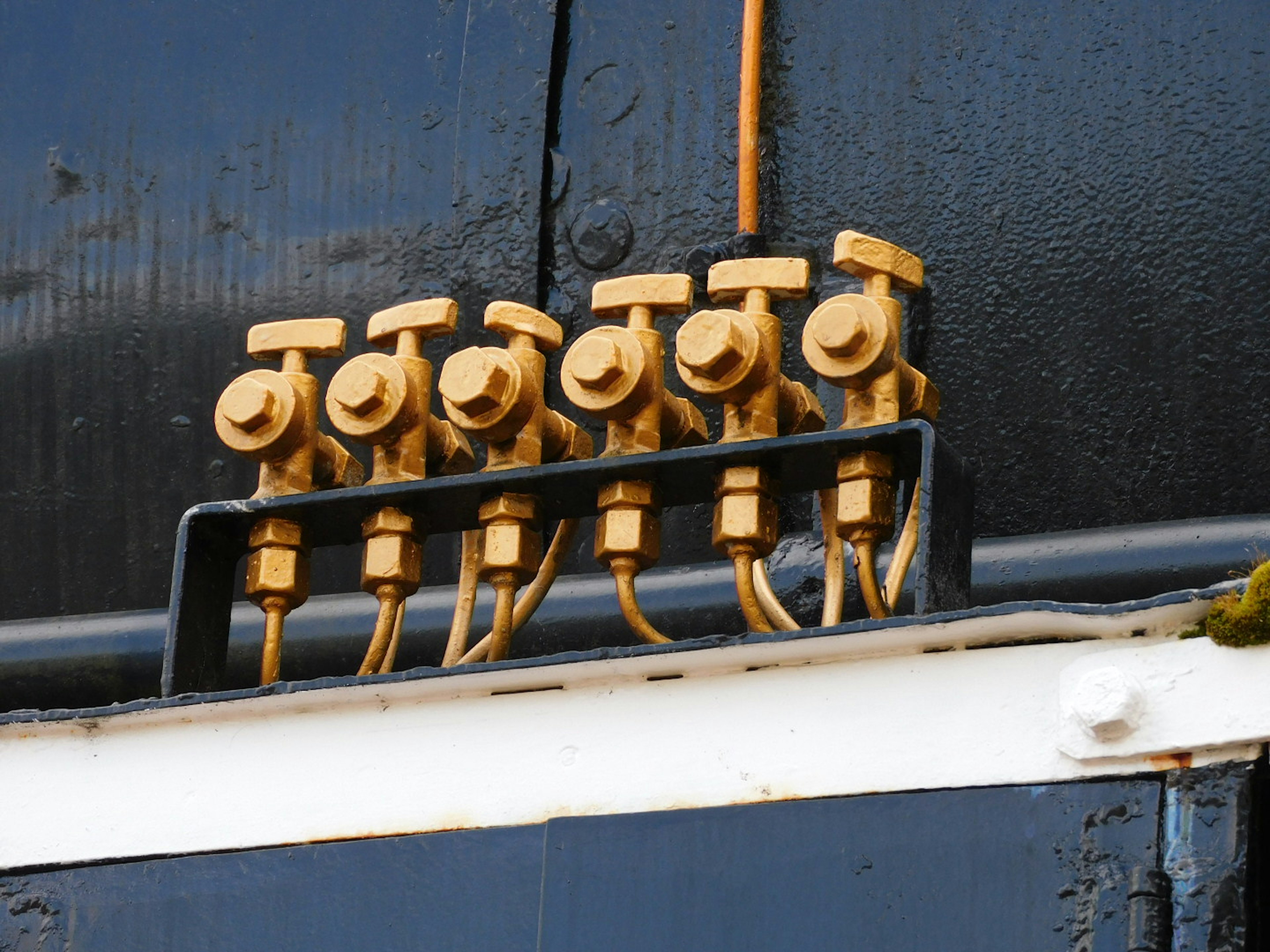 Image of six metal valves arranged in a connection panel