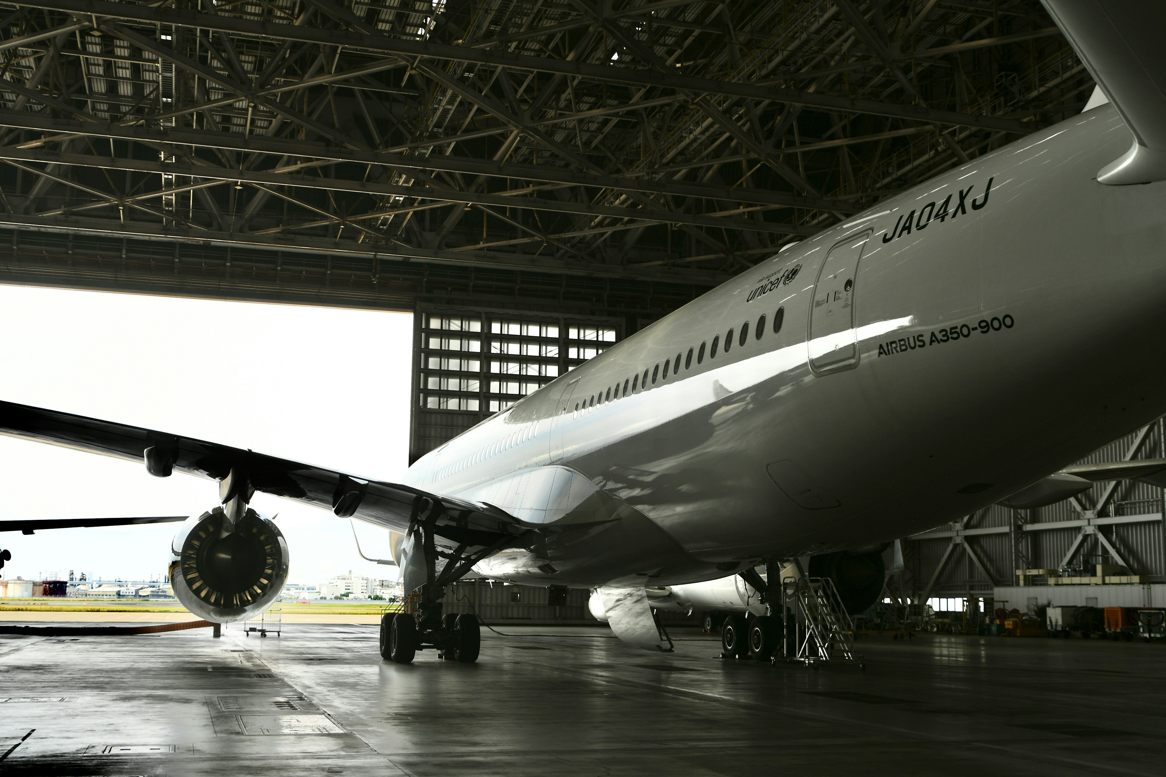 Airplane parked inside a hangar showcasing large engine and metallic structure