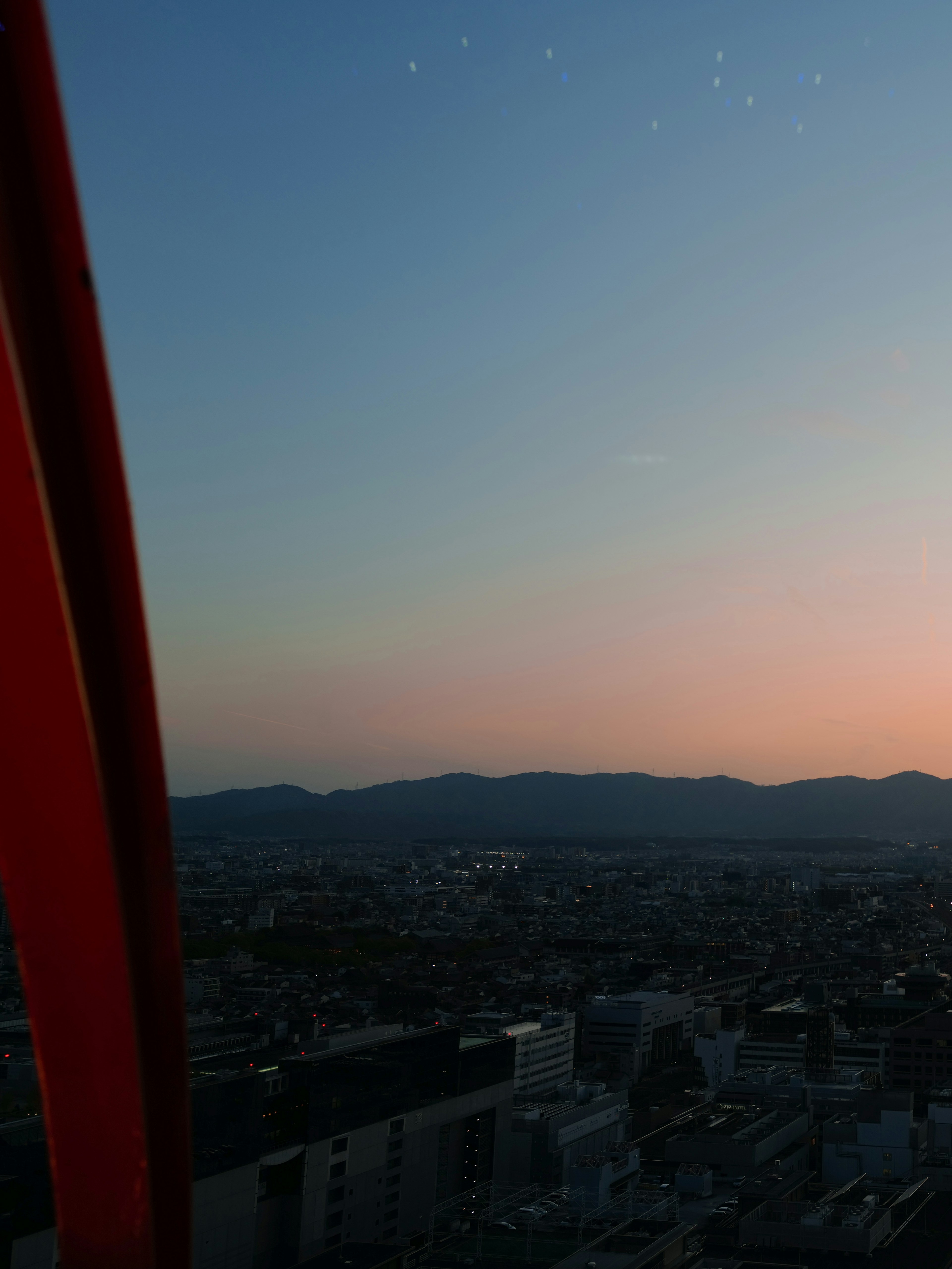 夜明け前の都市の景色と山々のシルエット