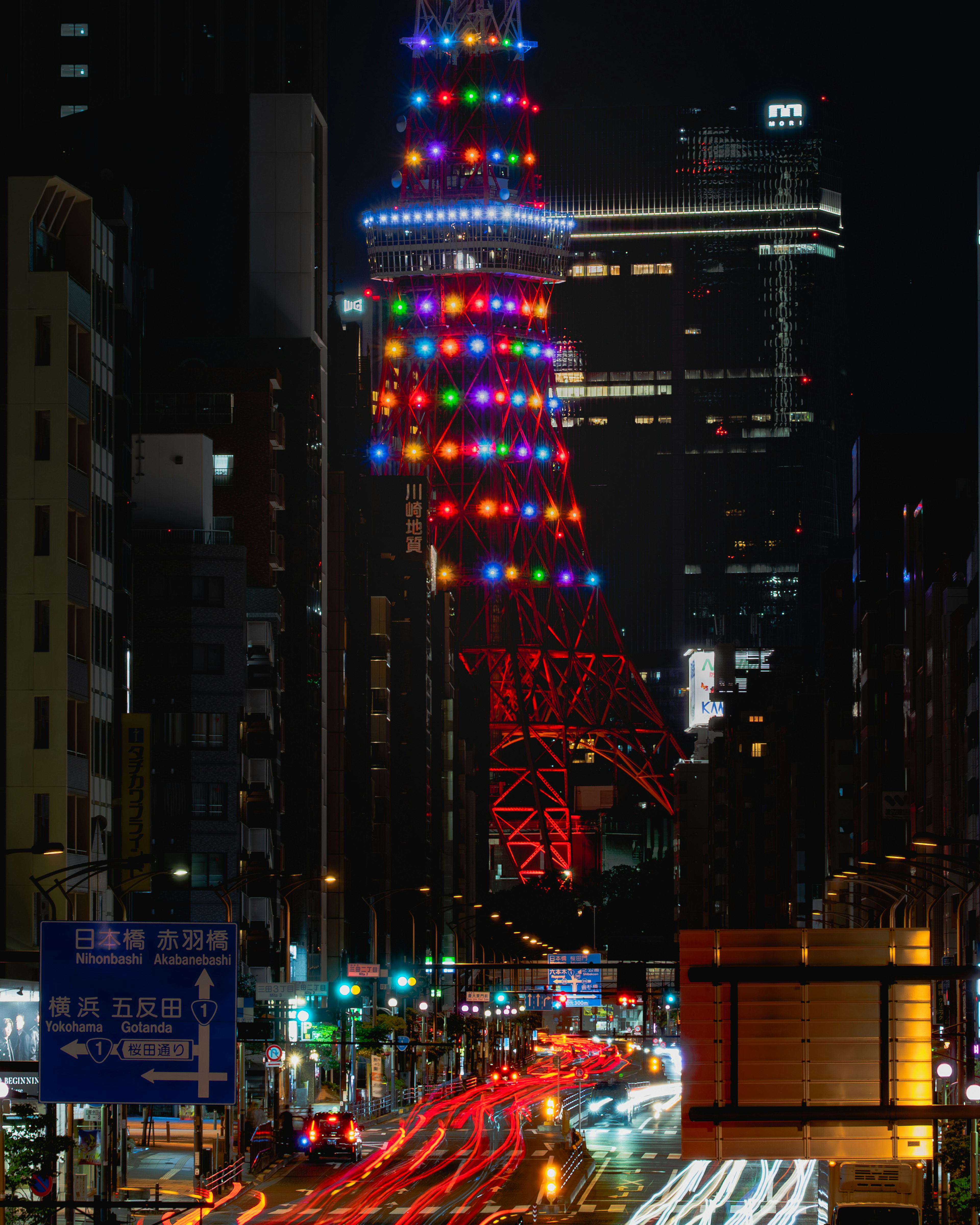 夜の東京タワーがカラフルなライトで装飾されている写真