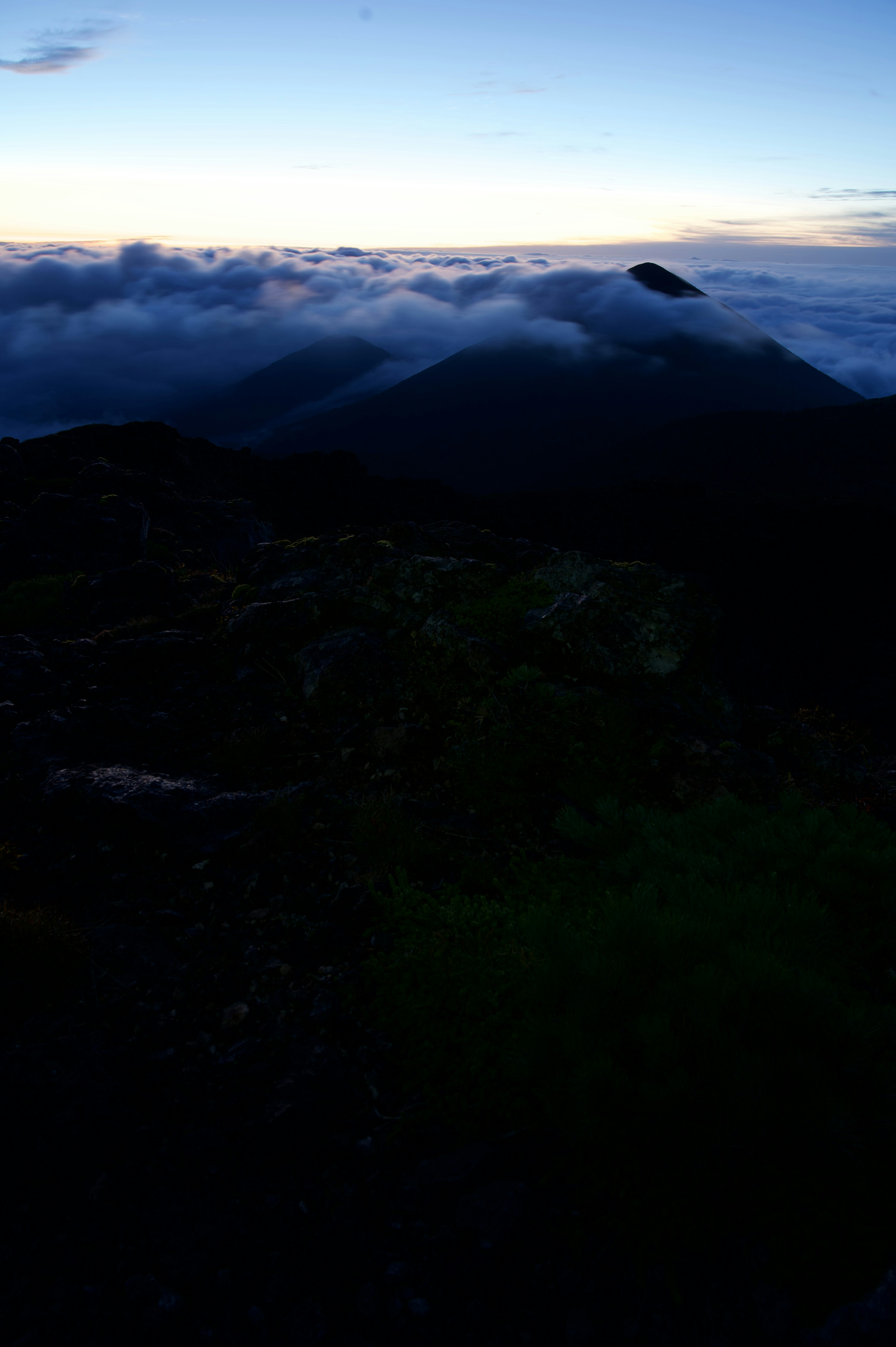 山の上からの夕暮れの風景、雲の下に広がる山々