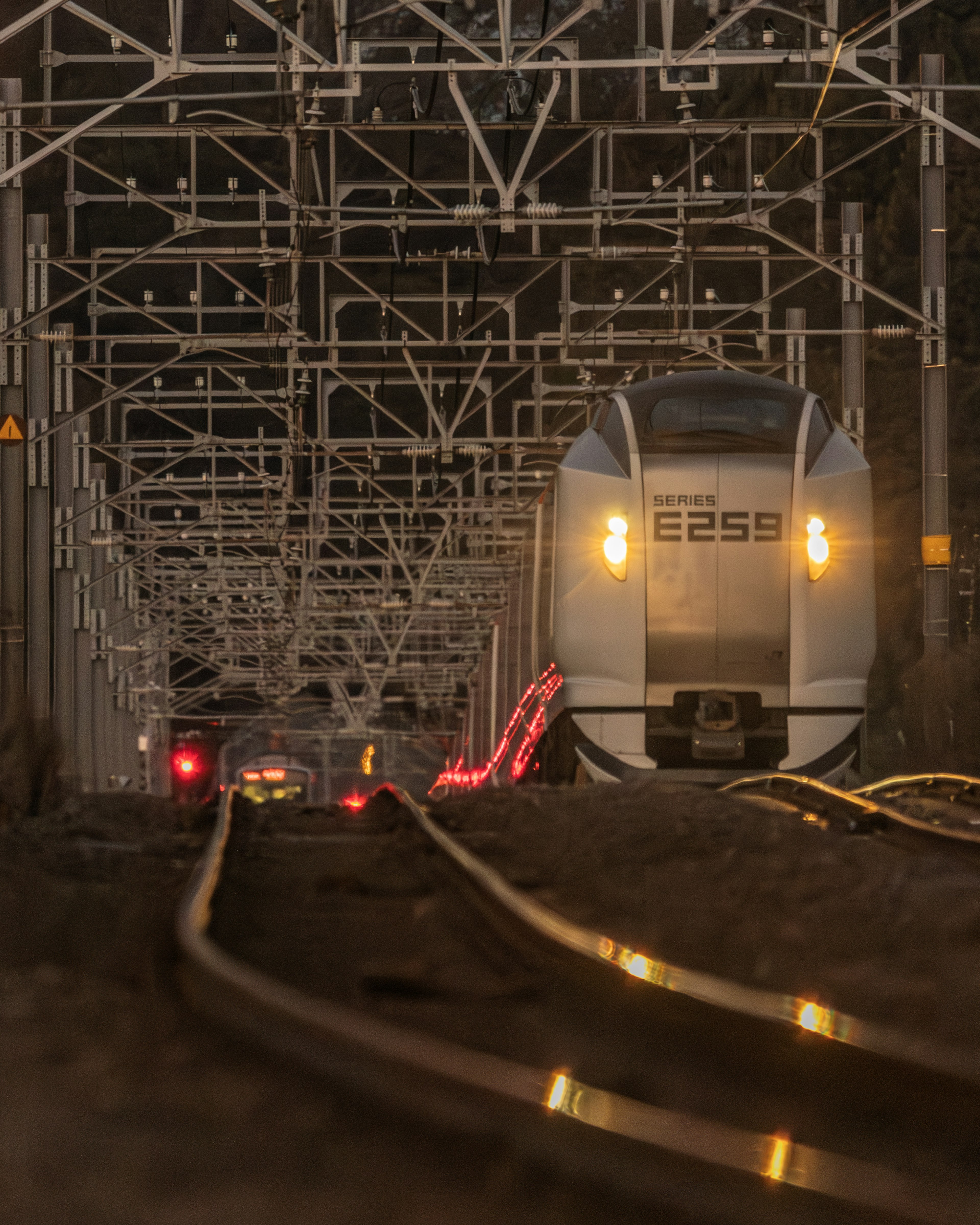 夜の鉄道駅の光と影の中にある列車とレール