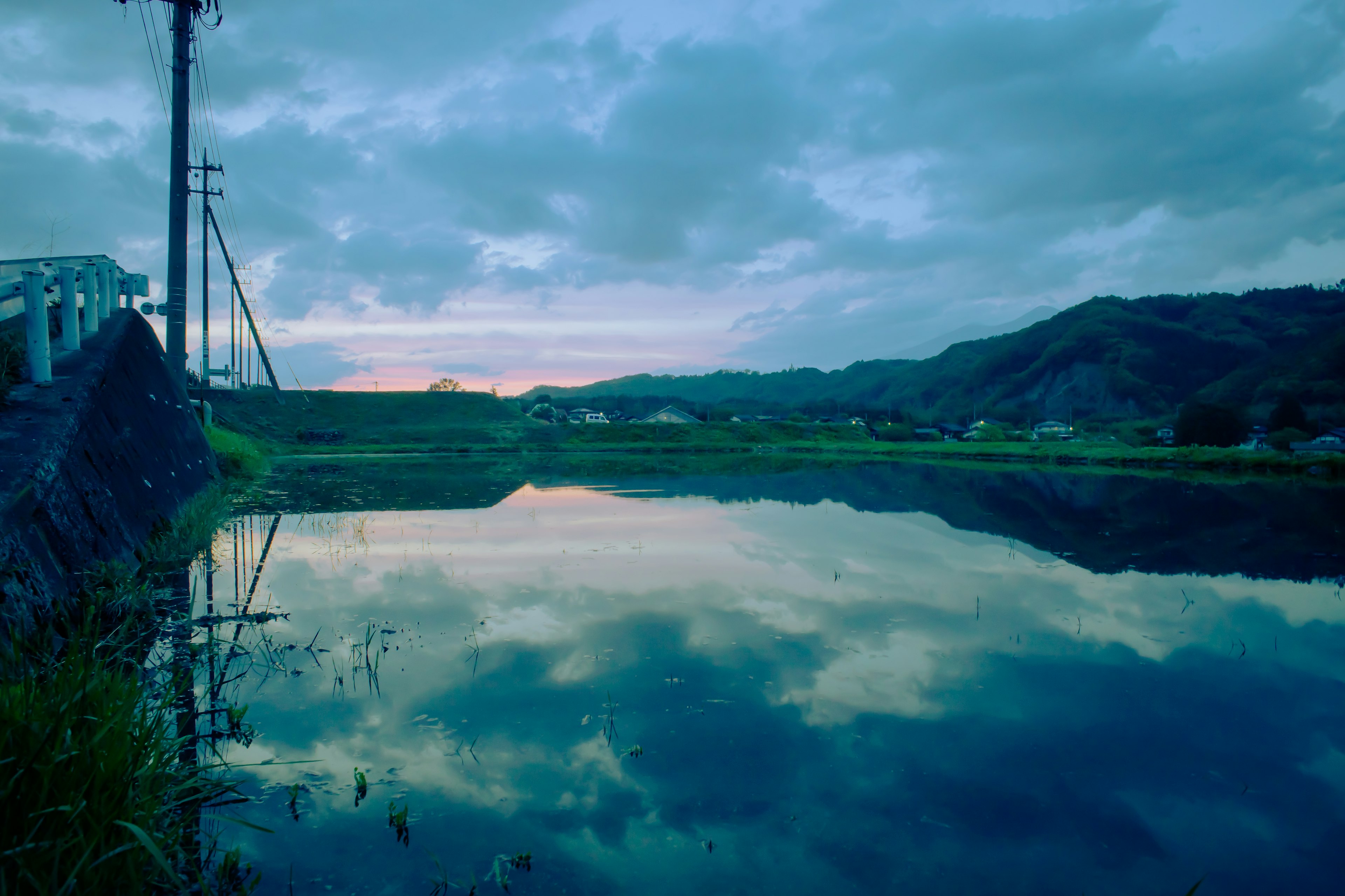 Calm rural landscape with clouds reflected in water