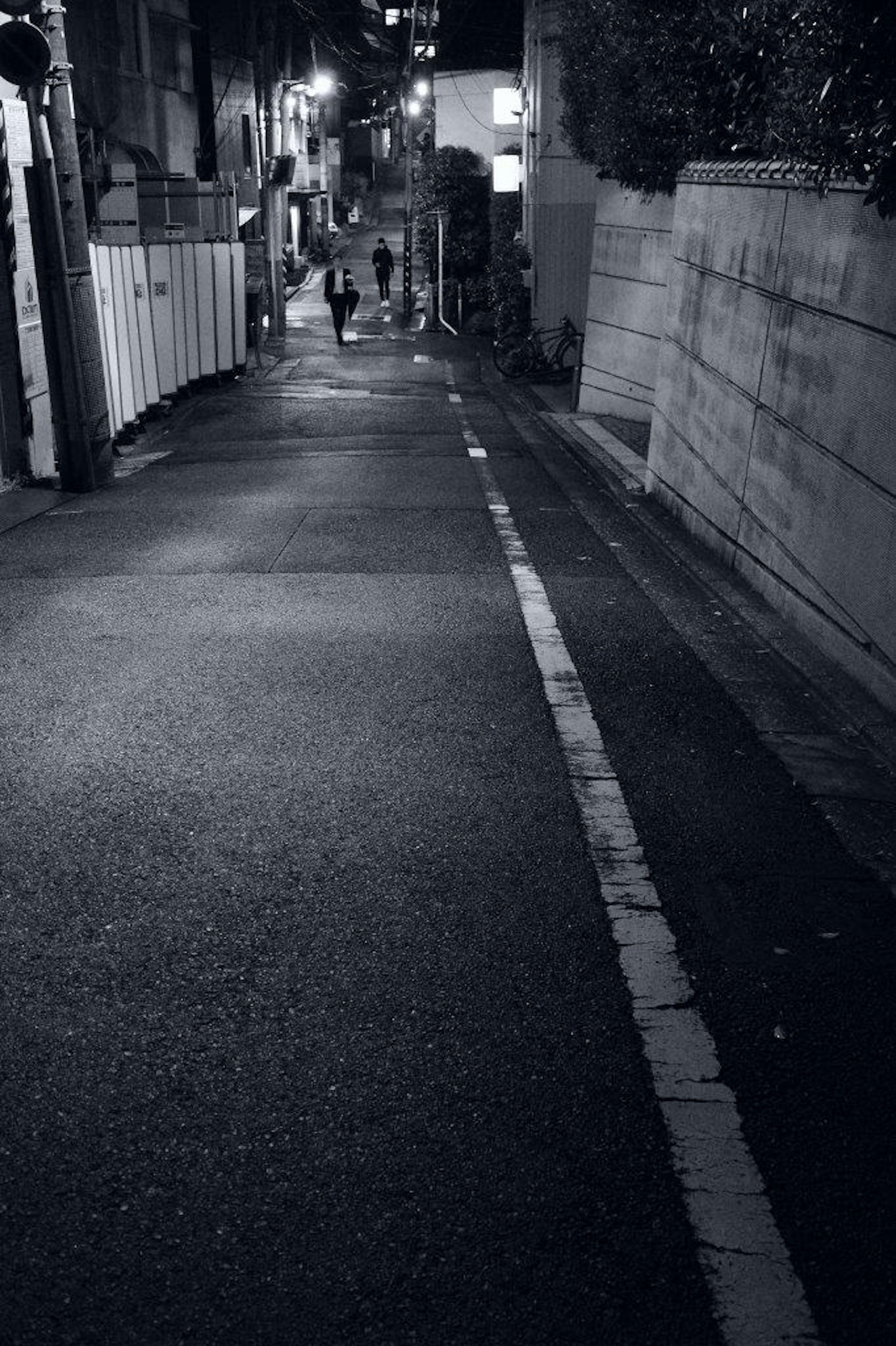 Nächtliche Szene einer dunklen Gasse mit Silhouetten von Menschen