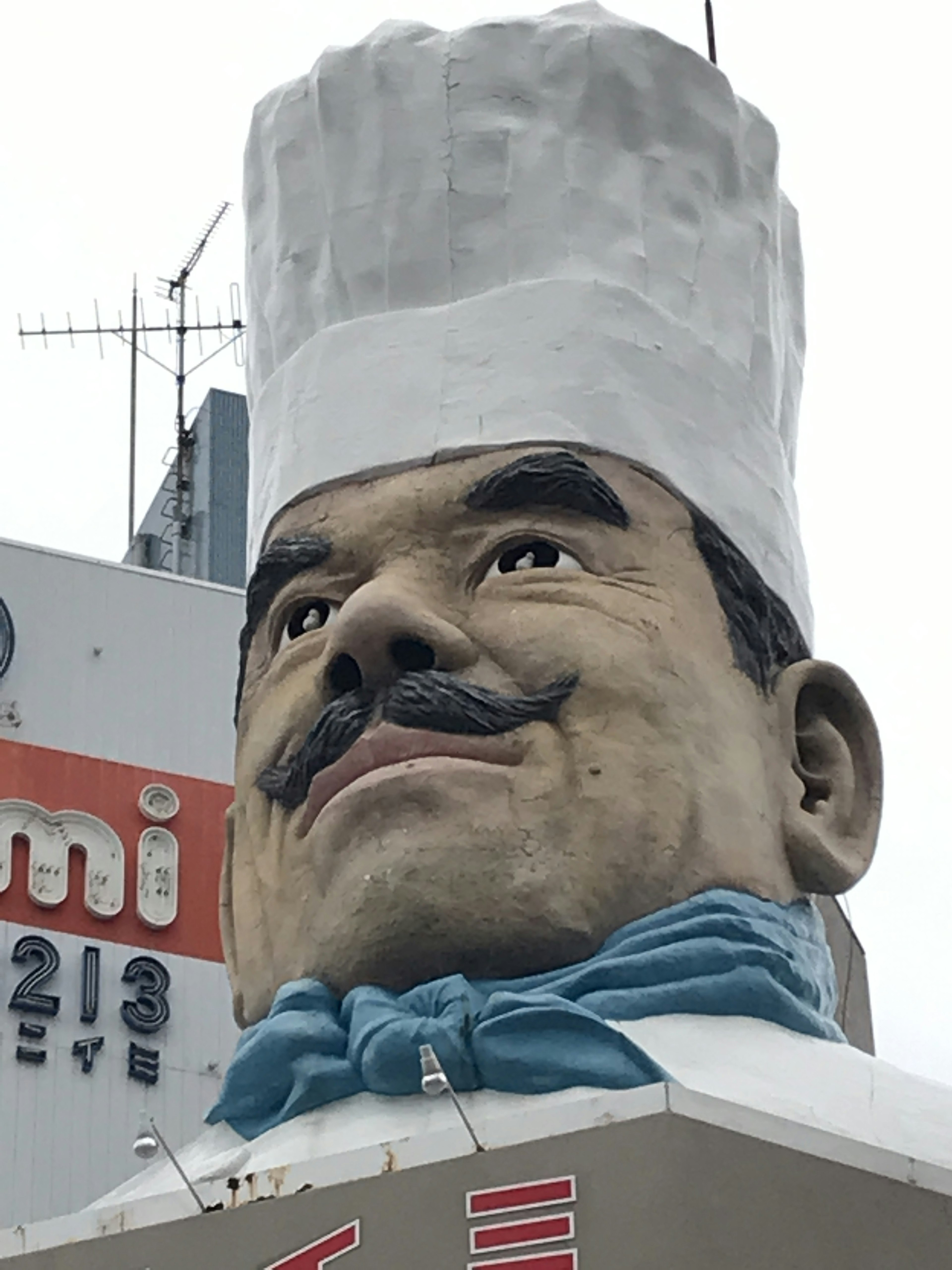 Oversized chef head sculpture on a sign