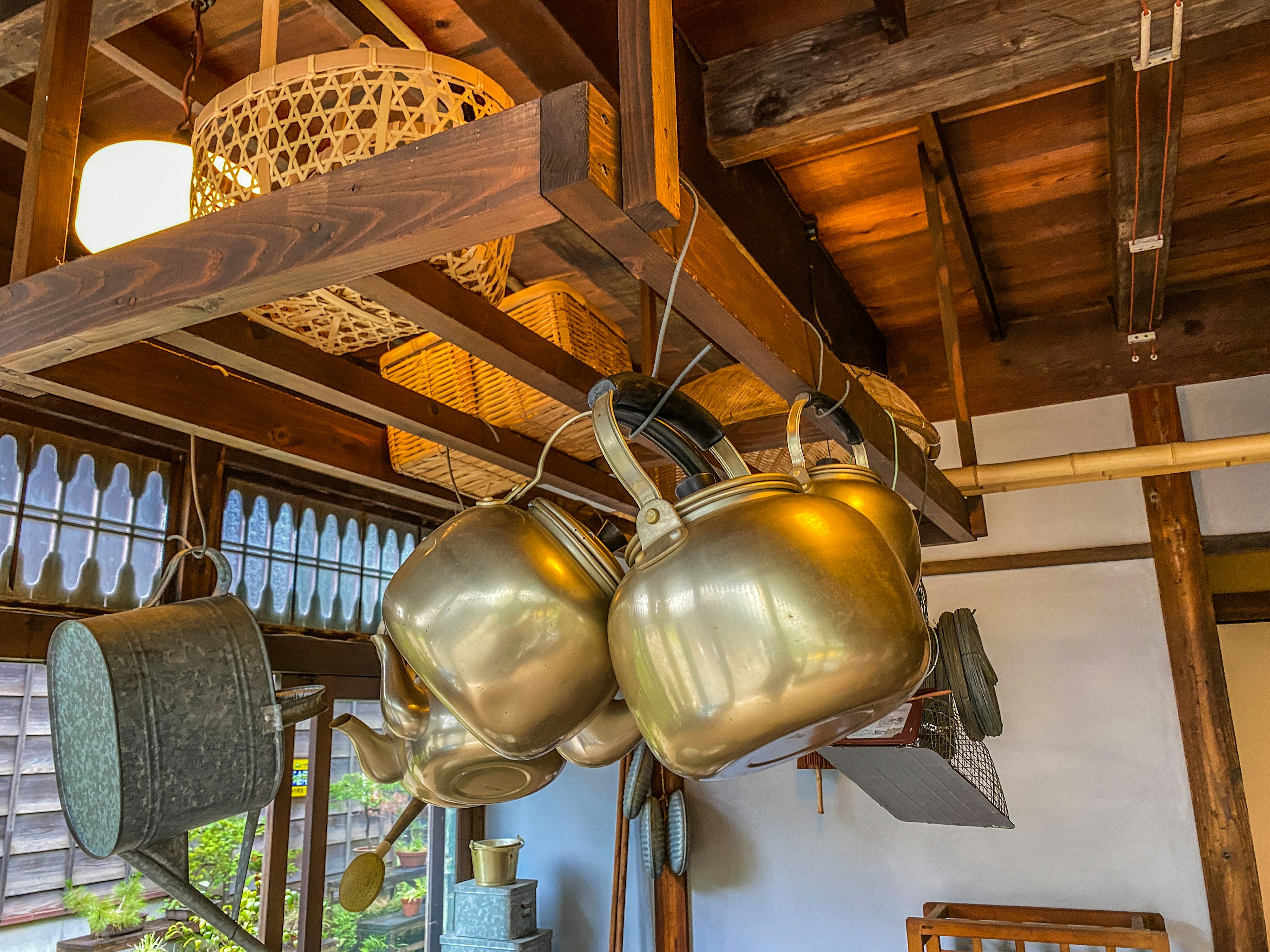 Interior de una cocina tradicional con ollas doradas colgantes