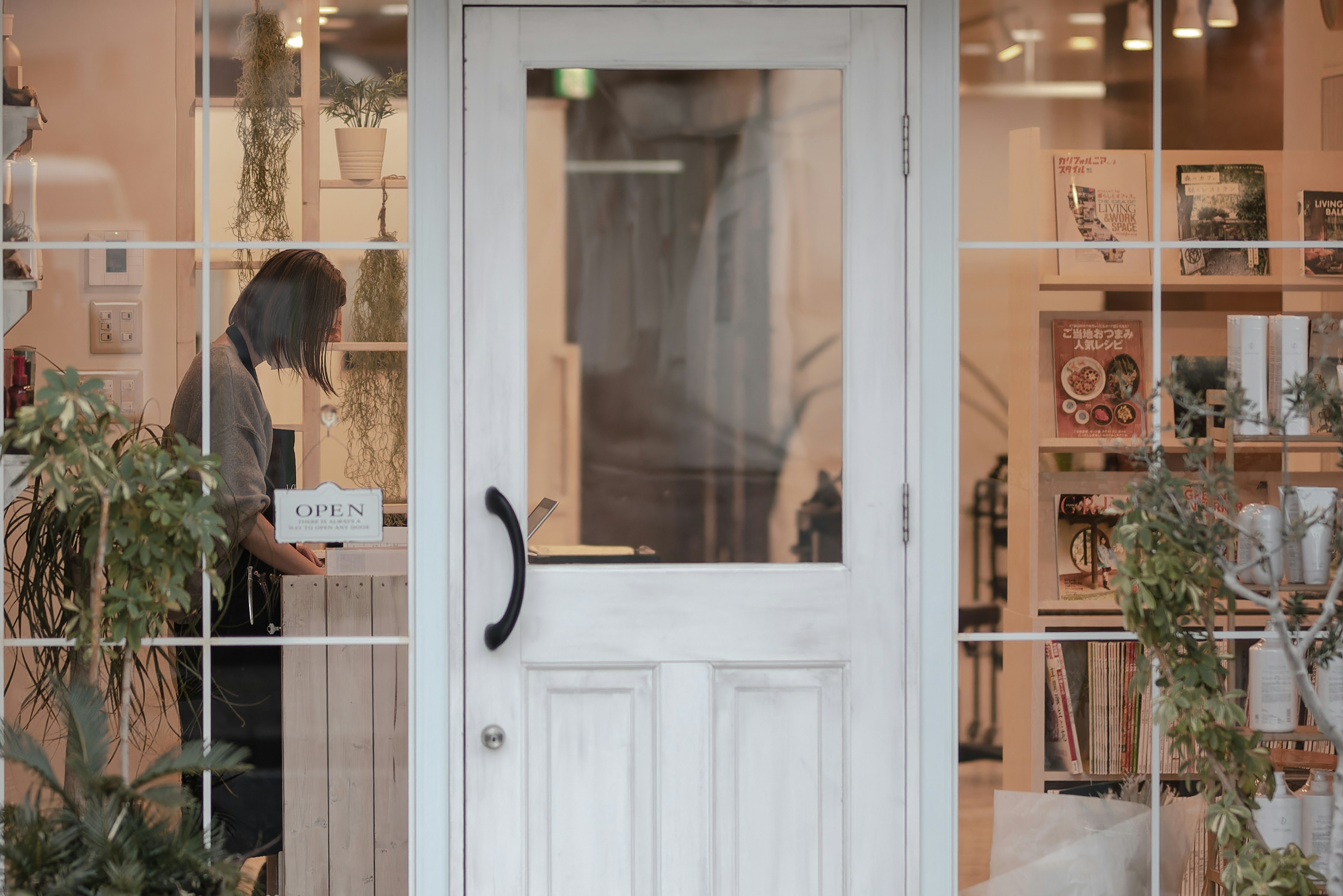 Vista exterior de una tienda con una puerta blanca y personal trabajando dentro