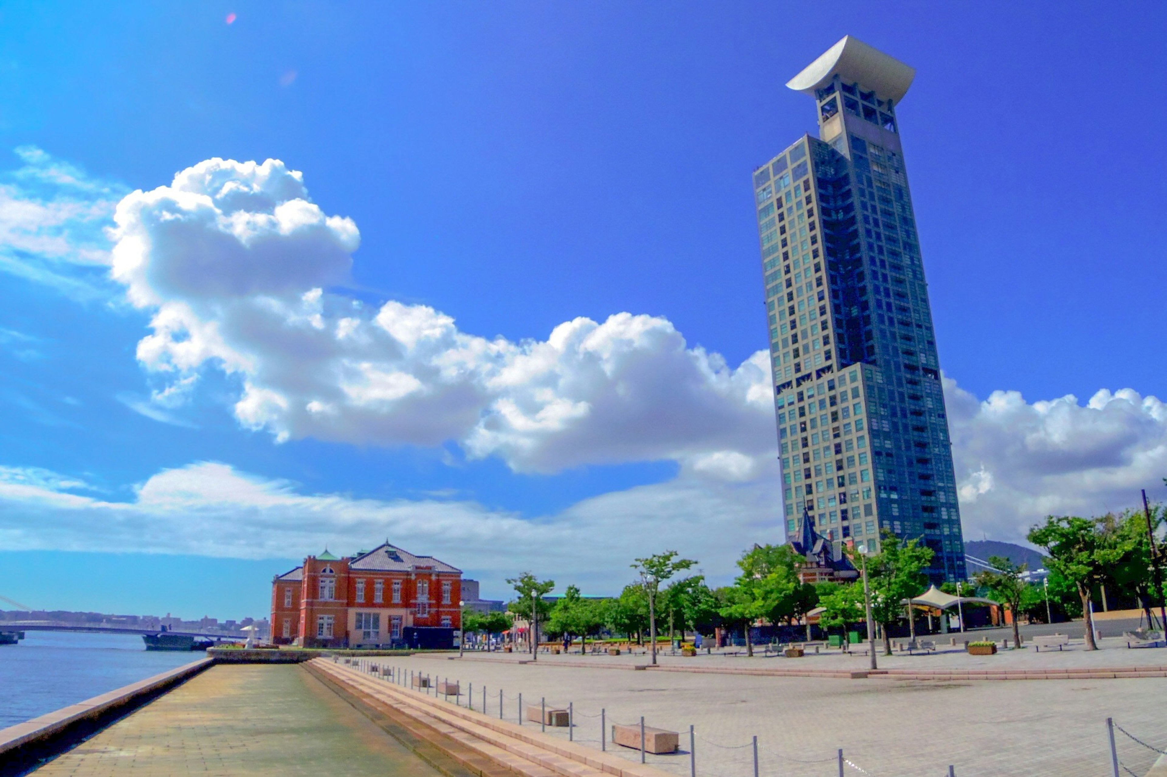 Modern skyscraper next to historic building along riverside