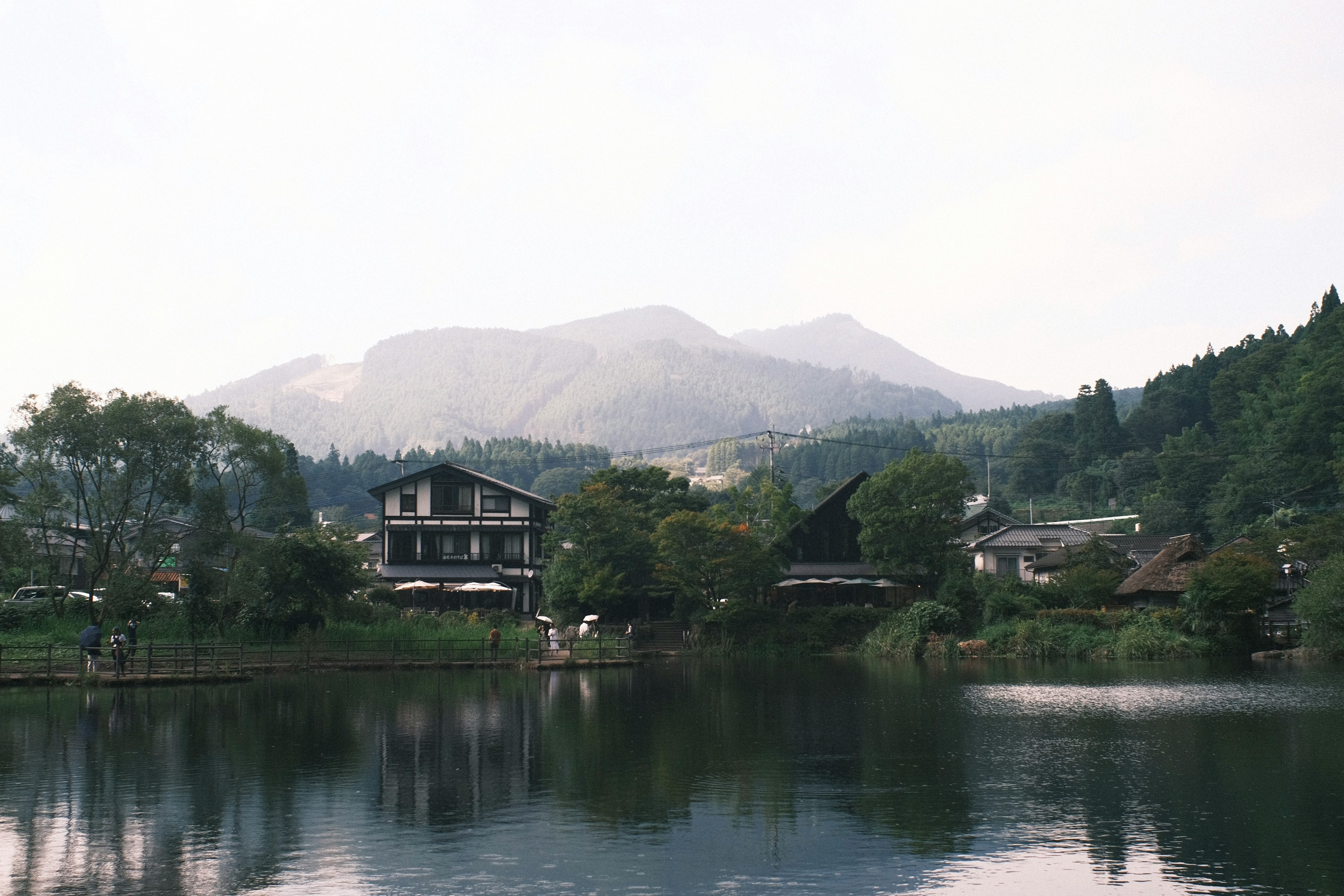 Un lago tranquilo rodeado de montañas con casas a lo largo de la orilla