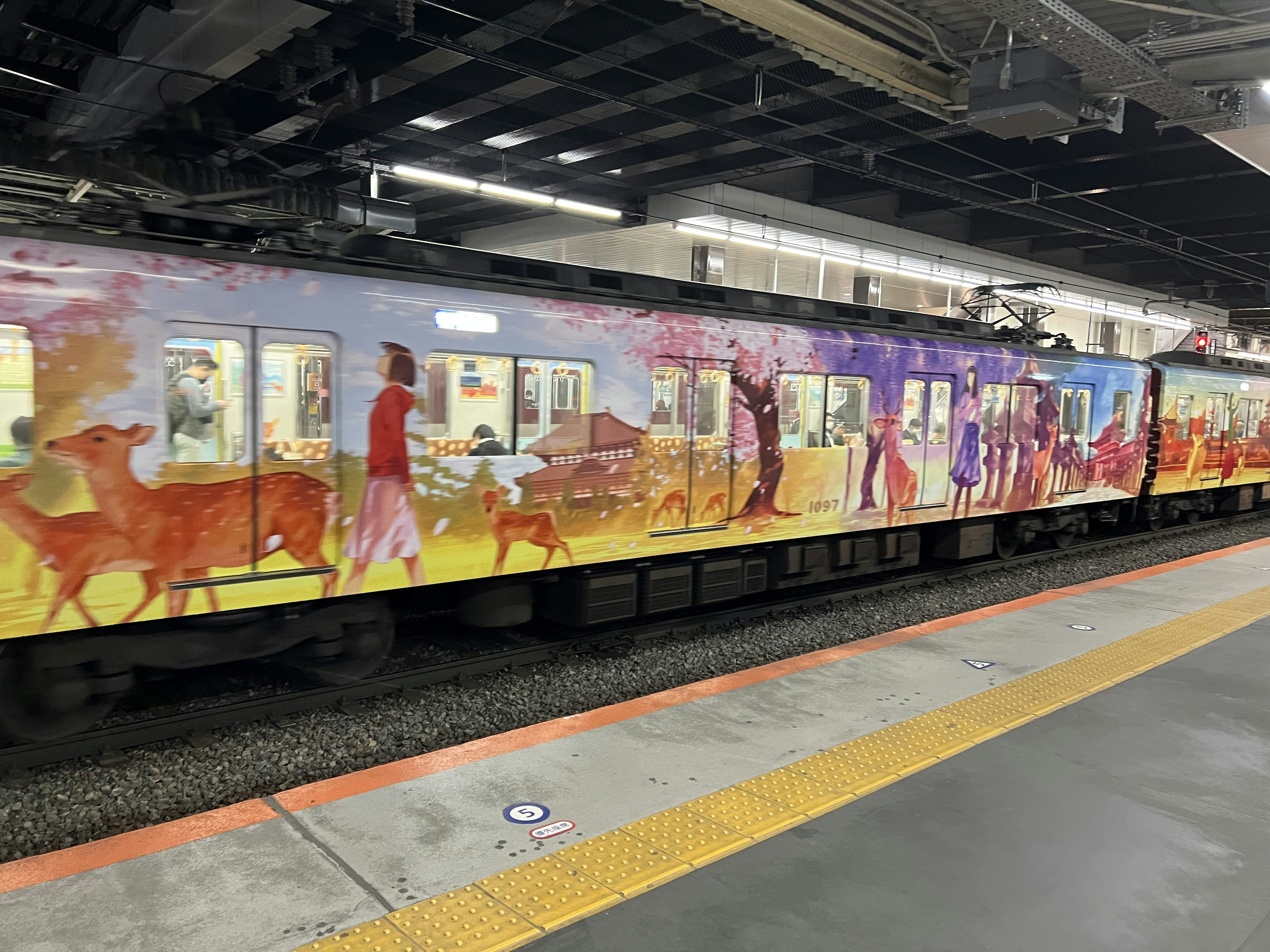 Un train décoré d'art vibrant à une station