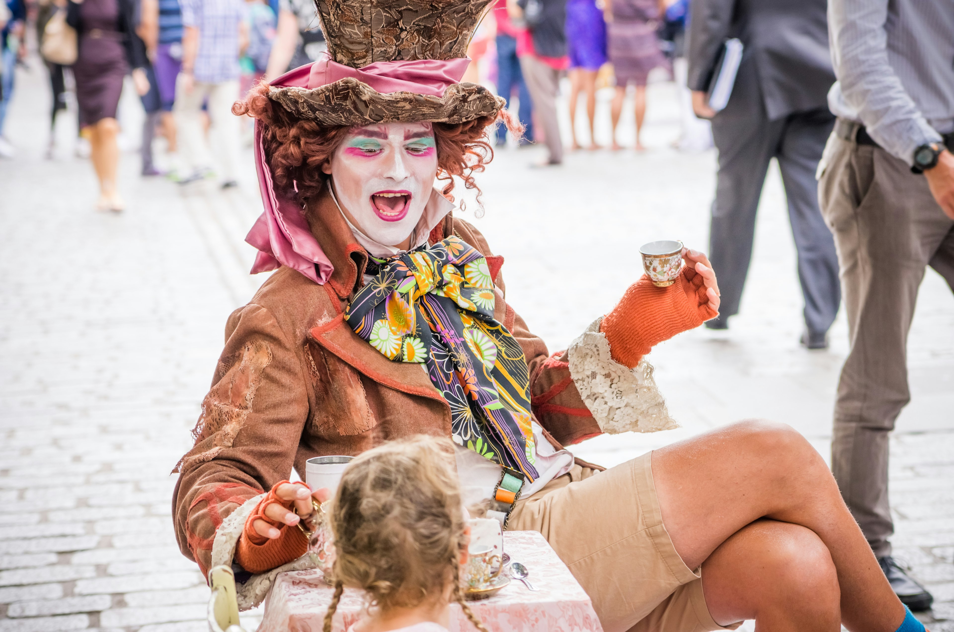 Un payaso colorido en un atuendo caprichoso interactuando con un niño