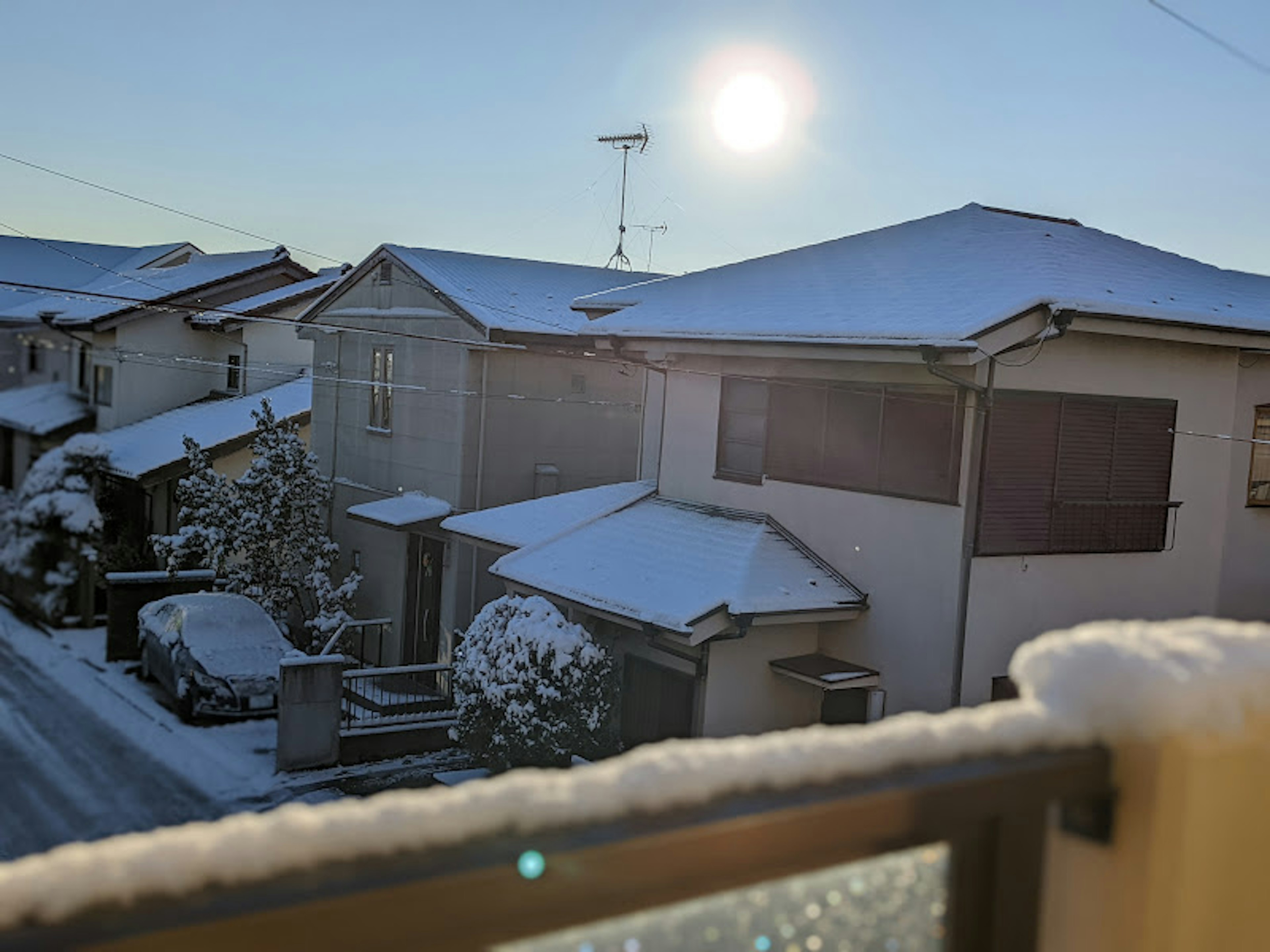 Snow-covered neighborhood with sunlight