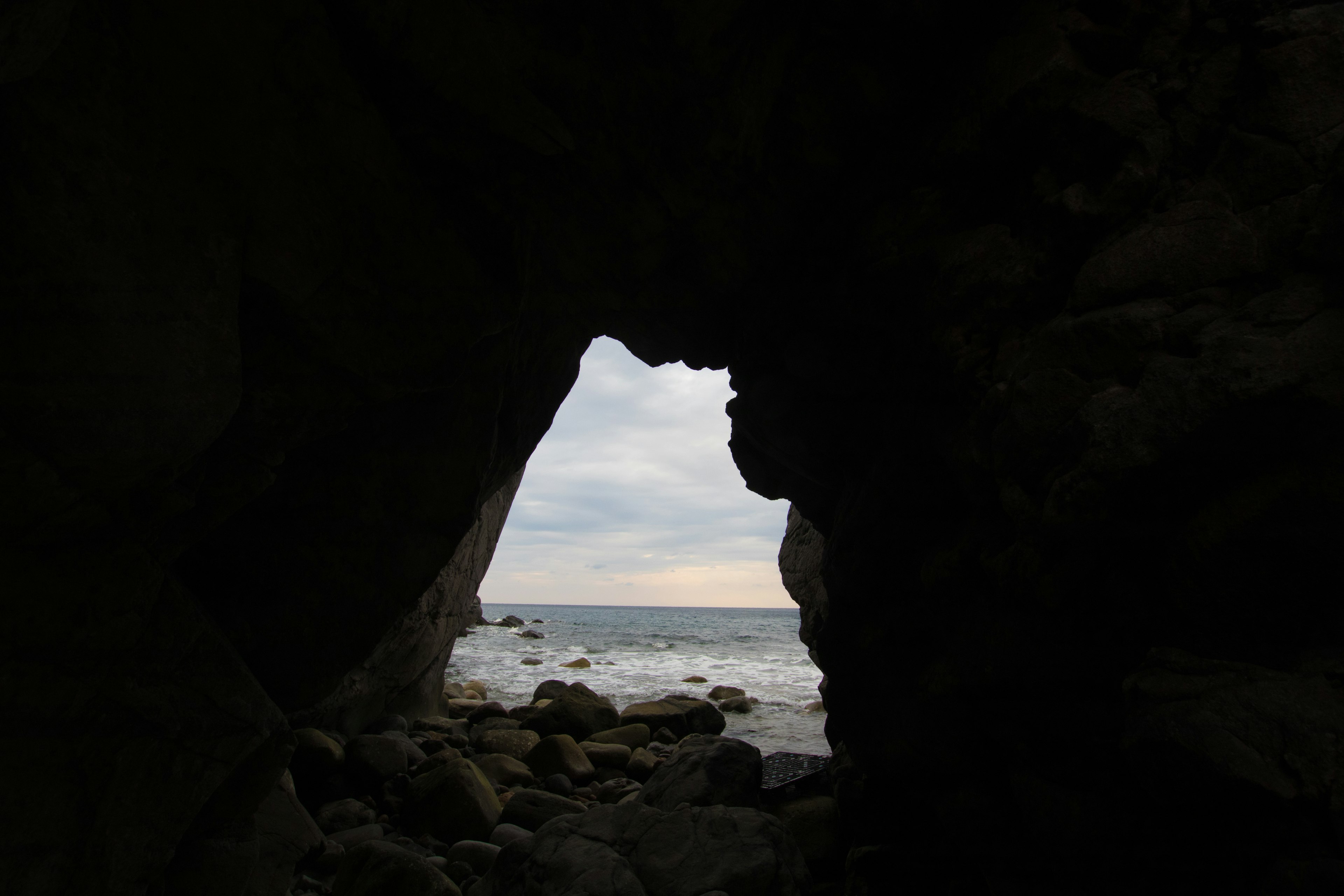 View of the sea and sky through a rocky cave opening