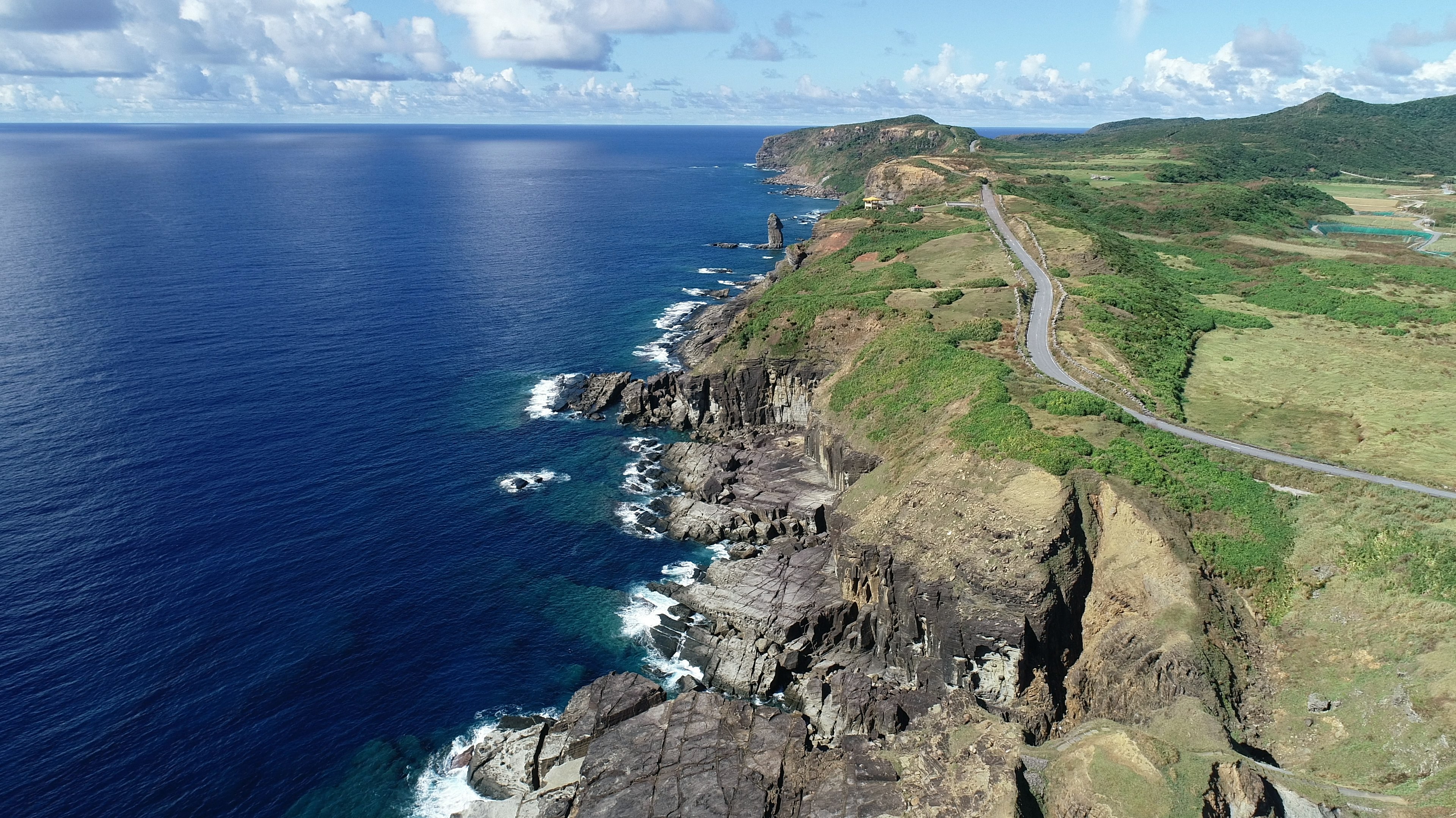 美丽的海岸风景 蓝色海洋 绿色丘陵和可见的道路