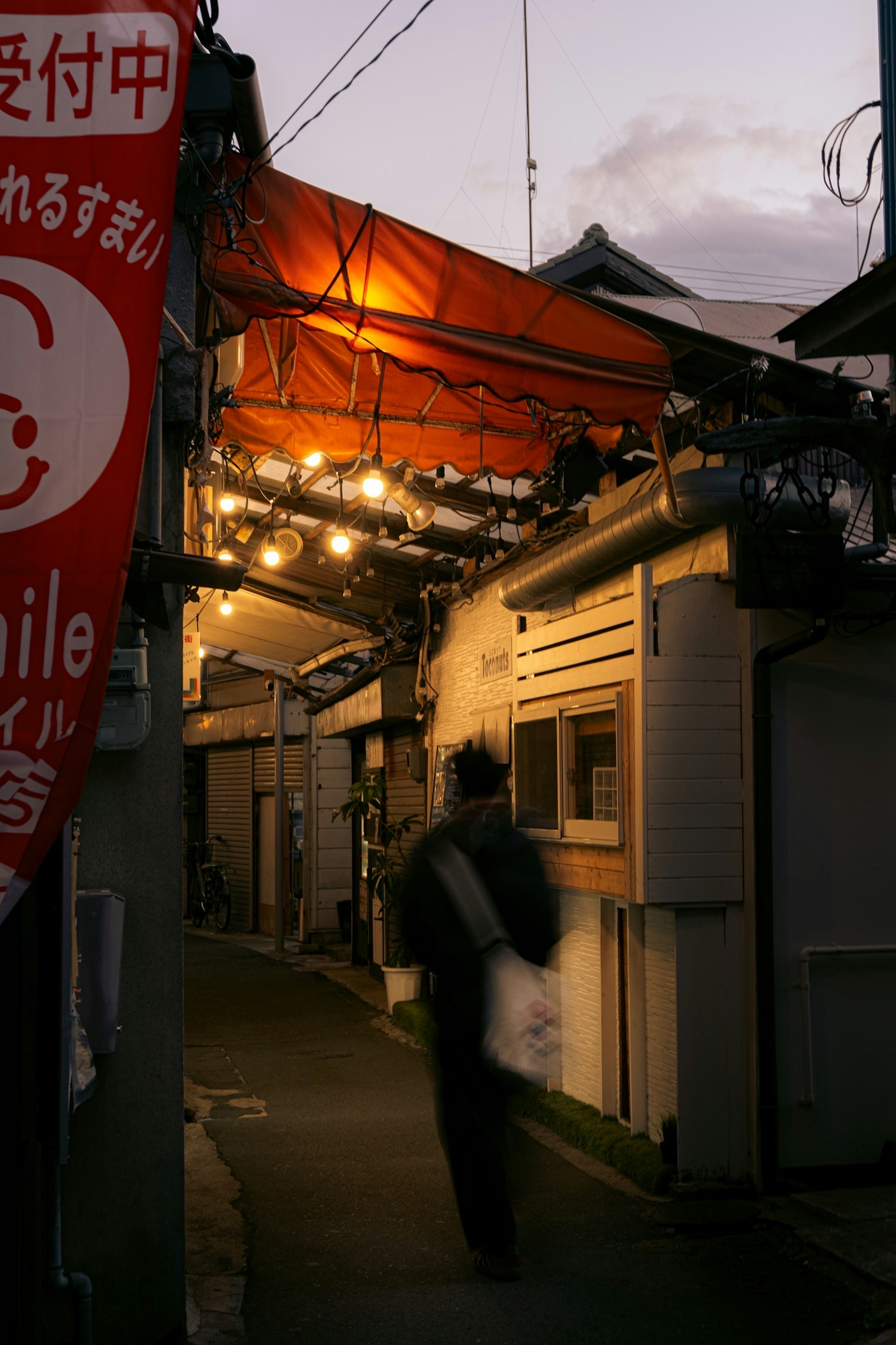 Allée du soir avec l'extérieur d'un restaurant et une personne marchant