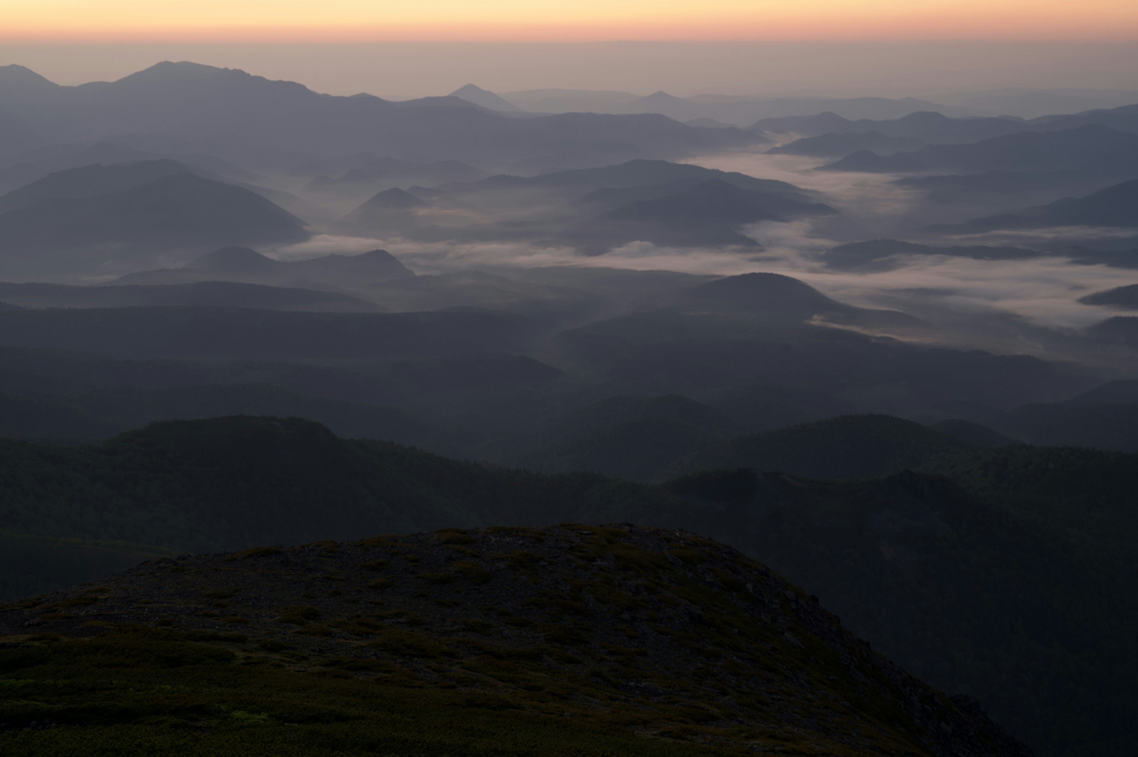 Paysage matinal avec des montagnes et vallées enveloppées de brouillard