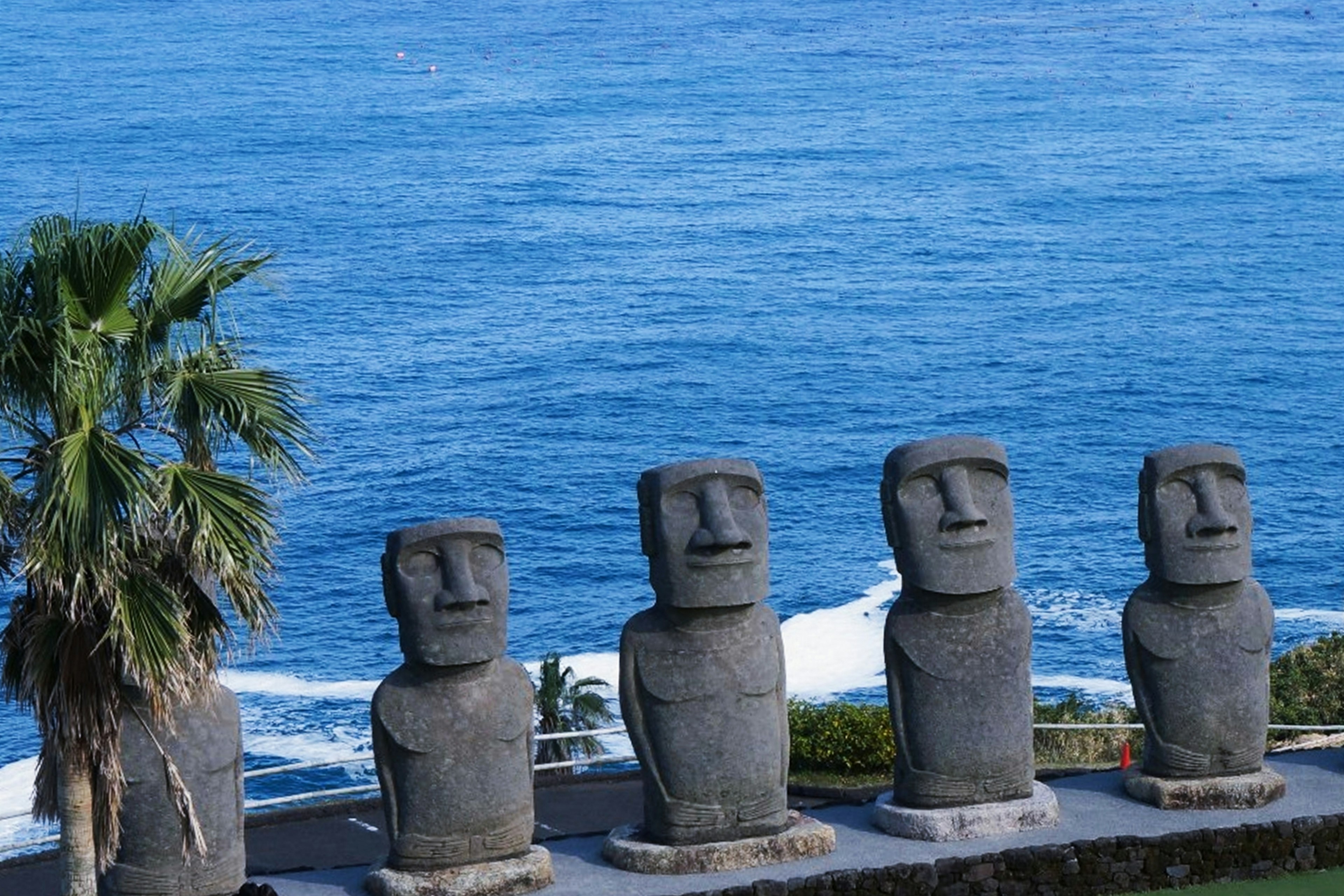 Row of Moai statues against the ocean backdrop