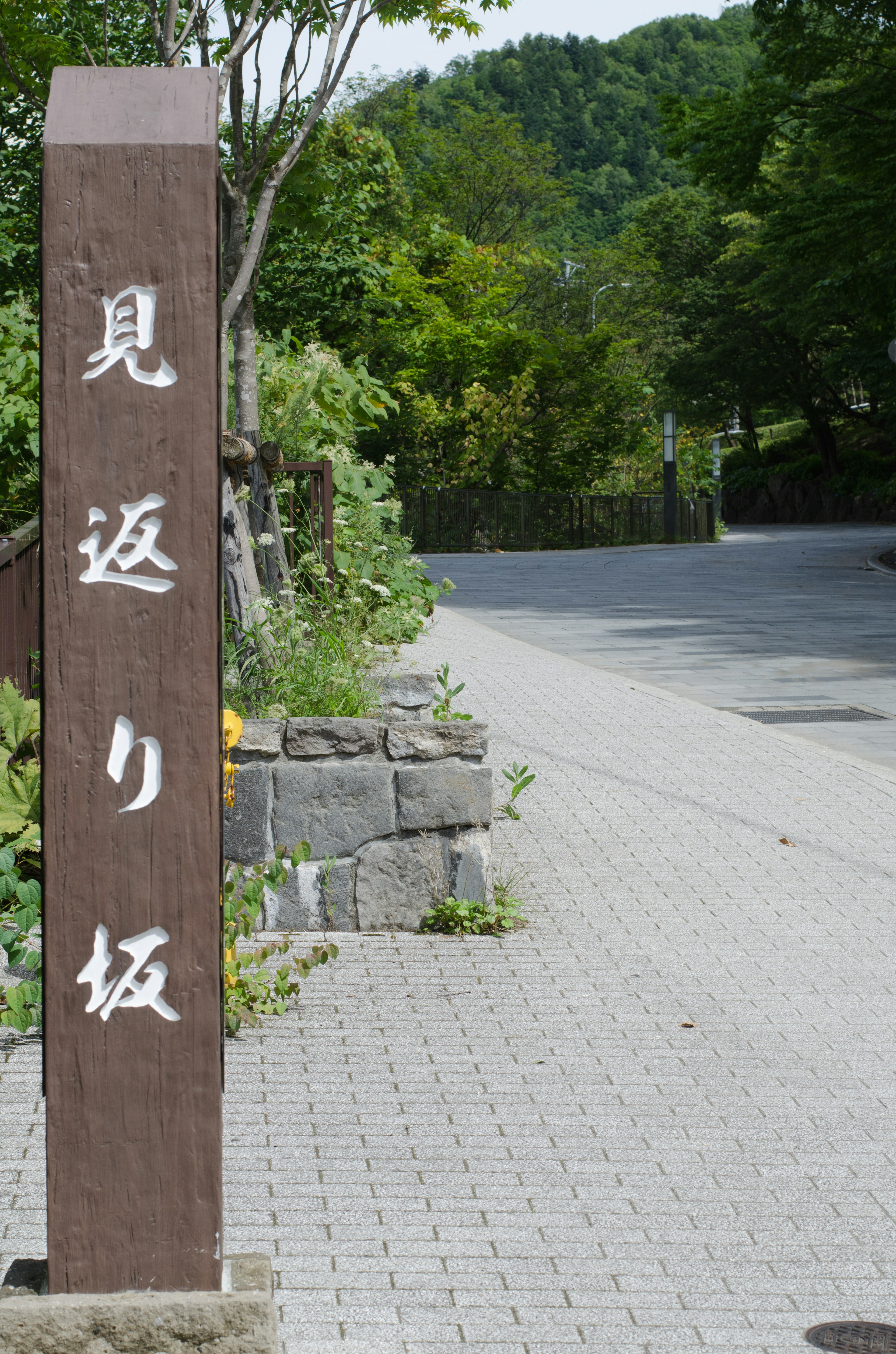 Sign for Mikkaerizaka on a lush green path