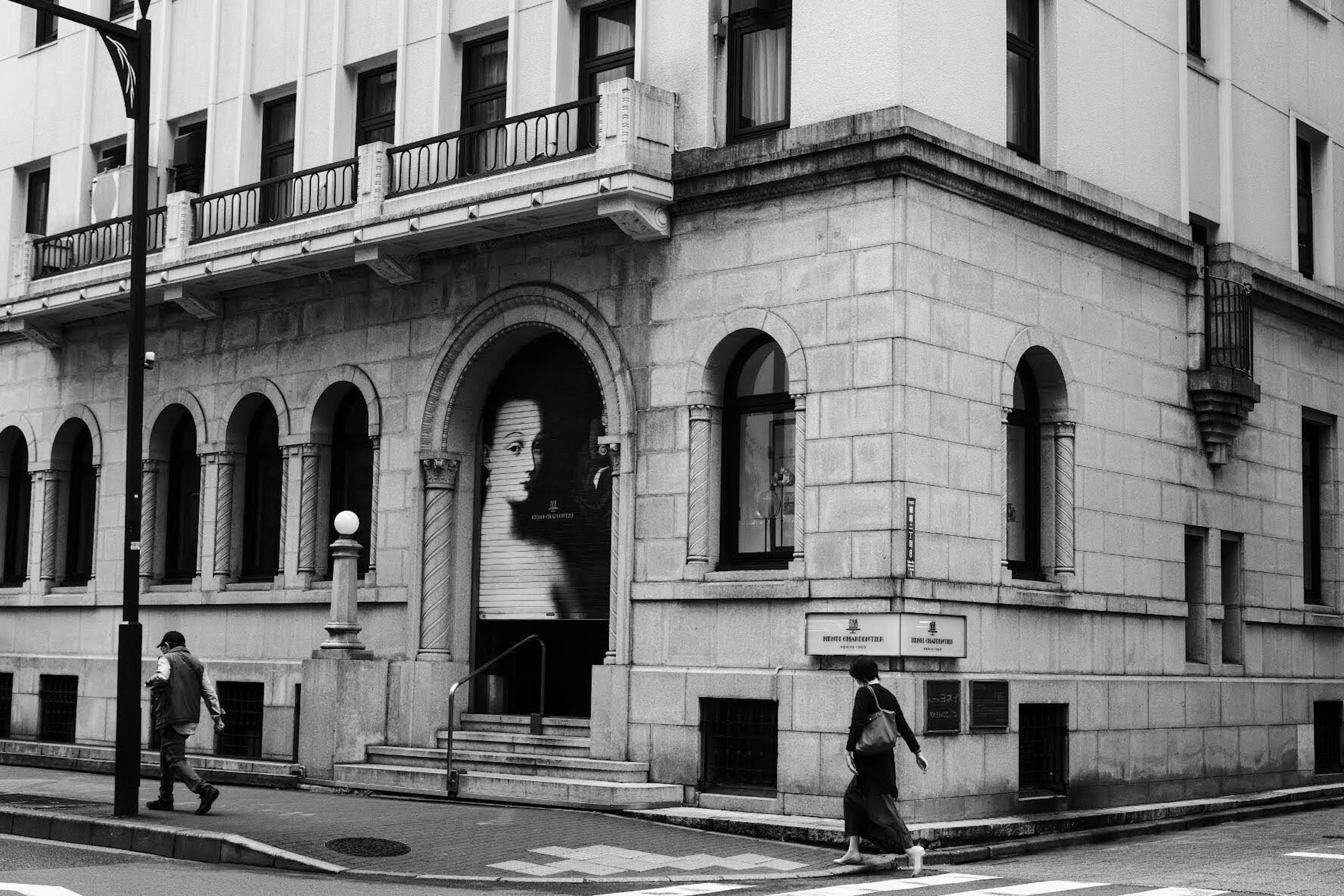 Bâtiment historique sur un coin de rue avec un grand portrait d'une femme