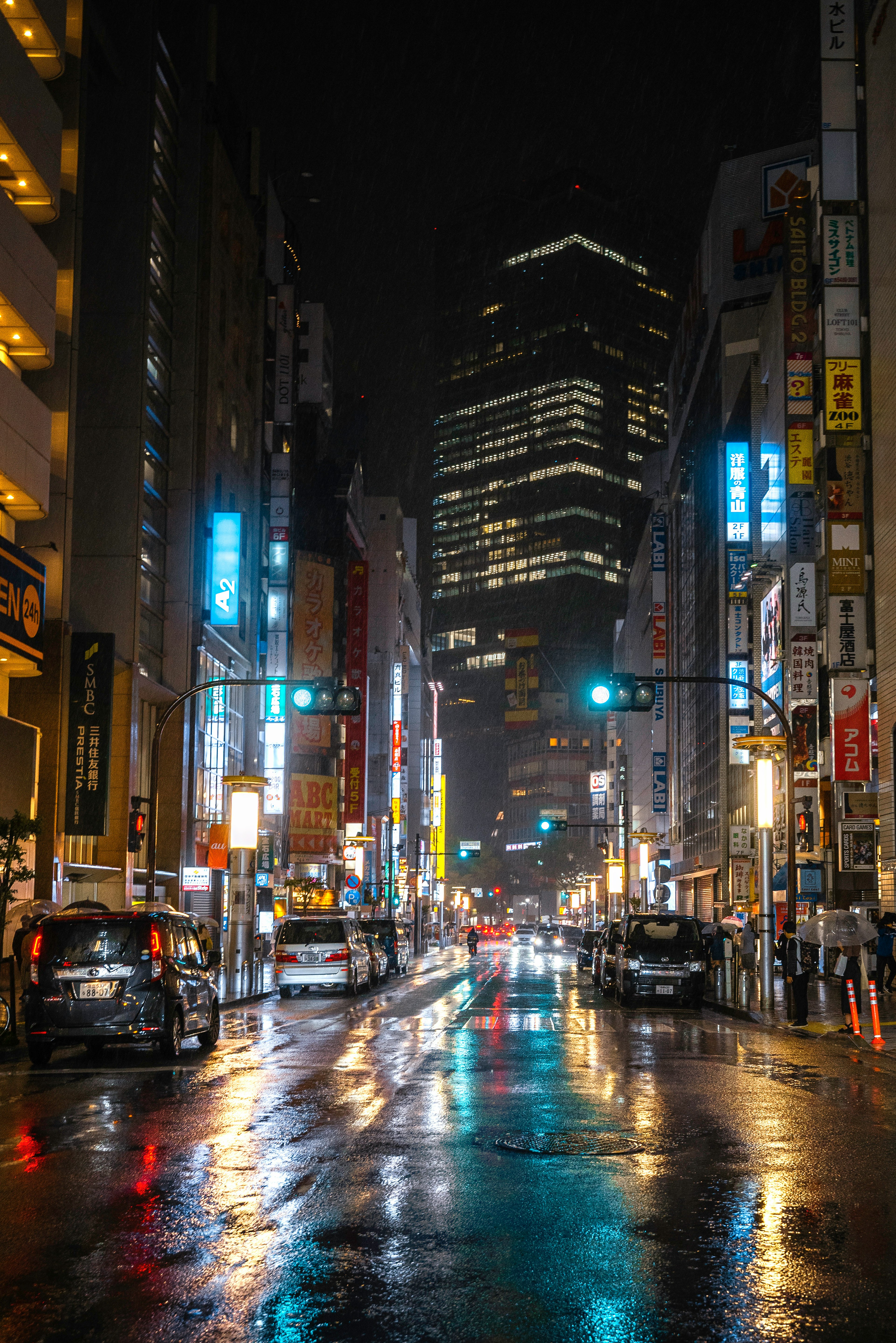 夜の都市の通り、反射する水たまりとビルの明かり