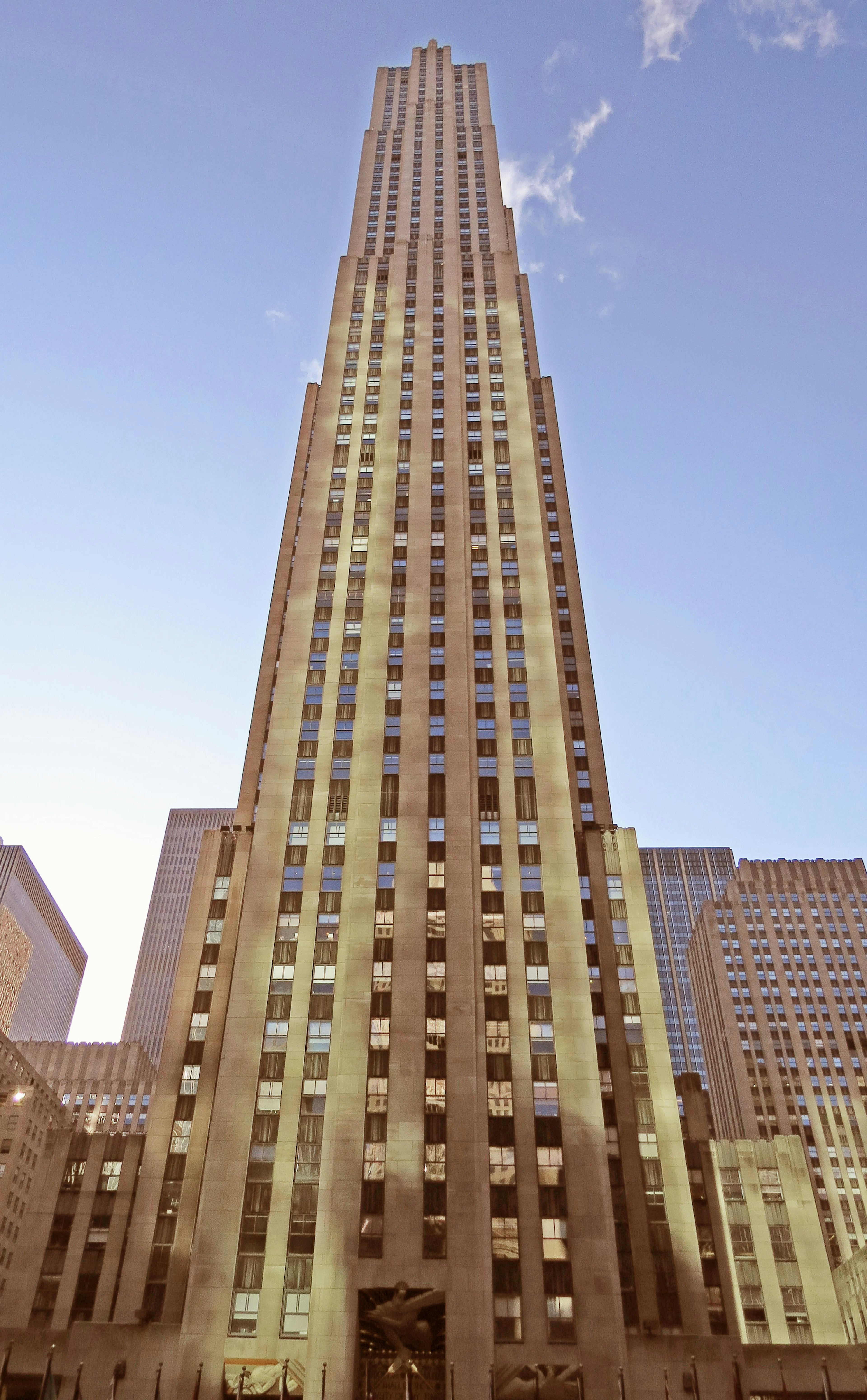 Image showcasing a skyscraper with a unique architectural design against a bright evening sky