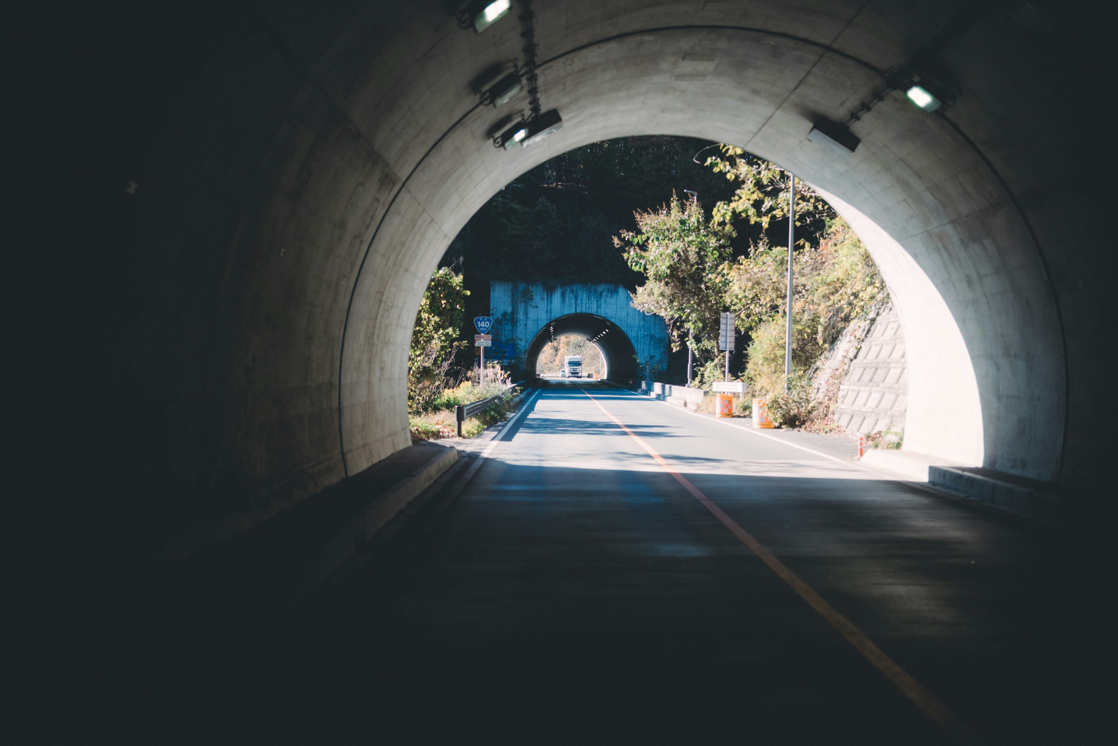 Vista dall'interno di un tunnel che mostra un'uscita luminosa e vegetazione circostante