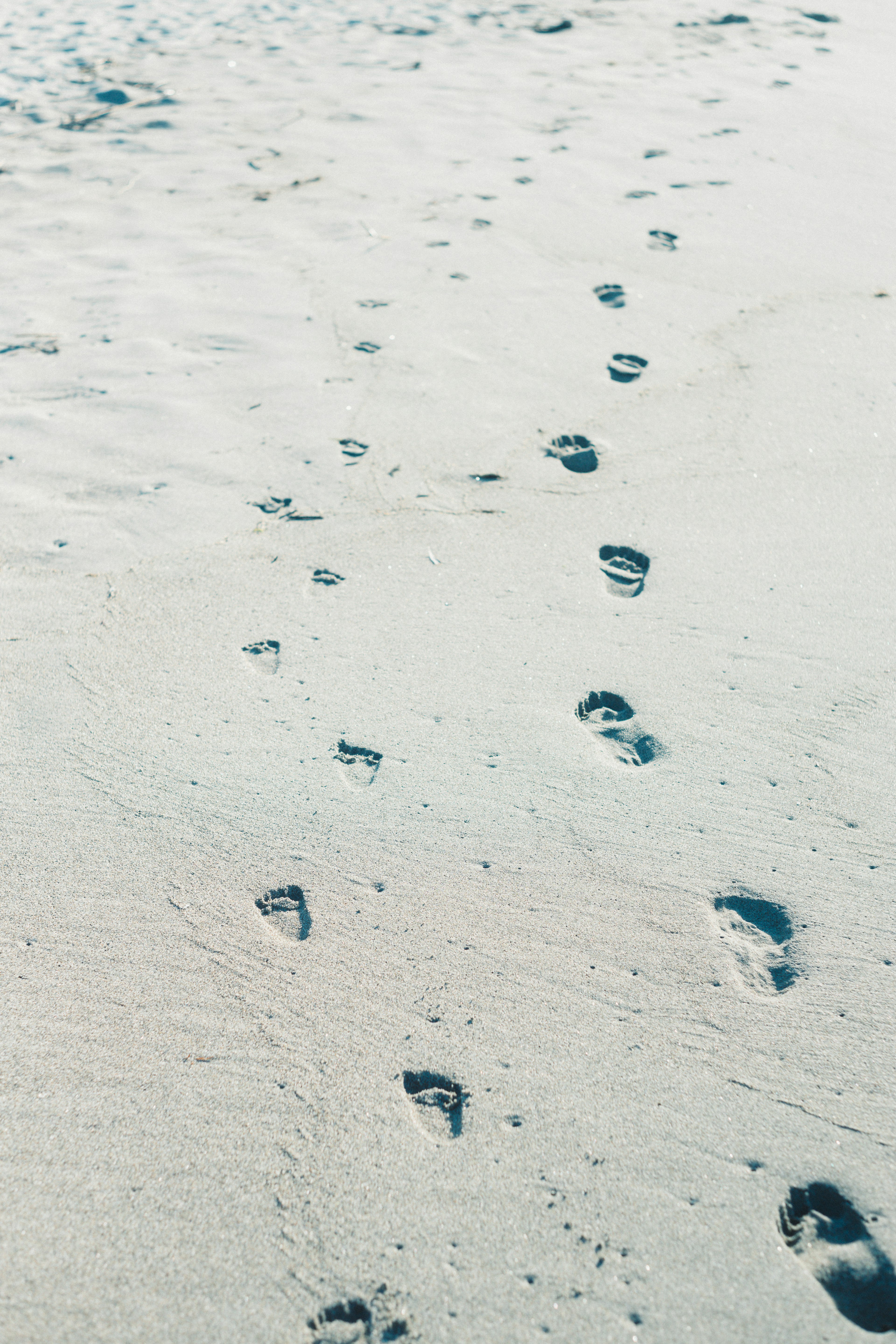 Footprints leading across a sandy beach