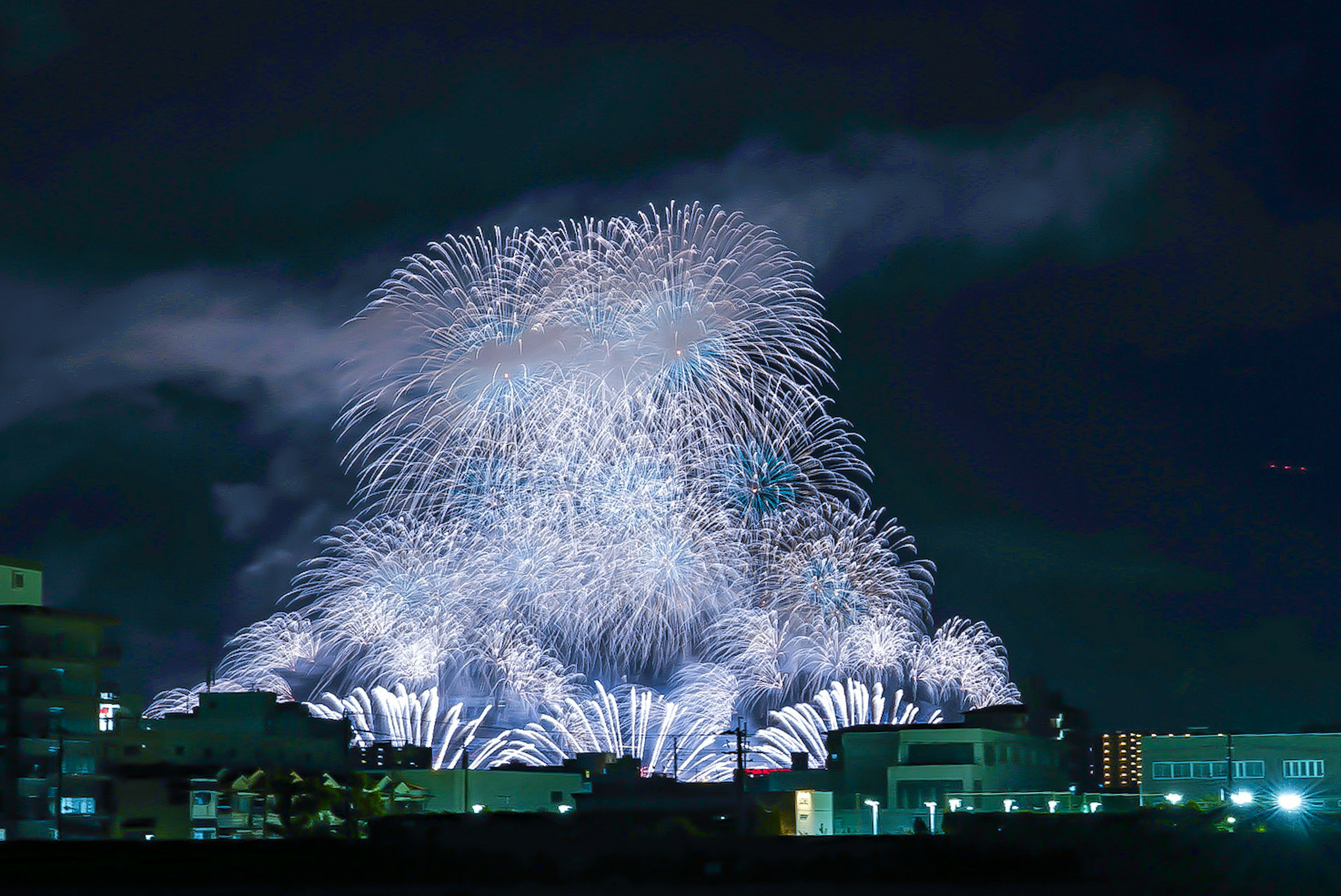 Spettacolare spettacolo di fuochi d'artificio nel cielo notturno con luci blu e bianche impressionanti