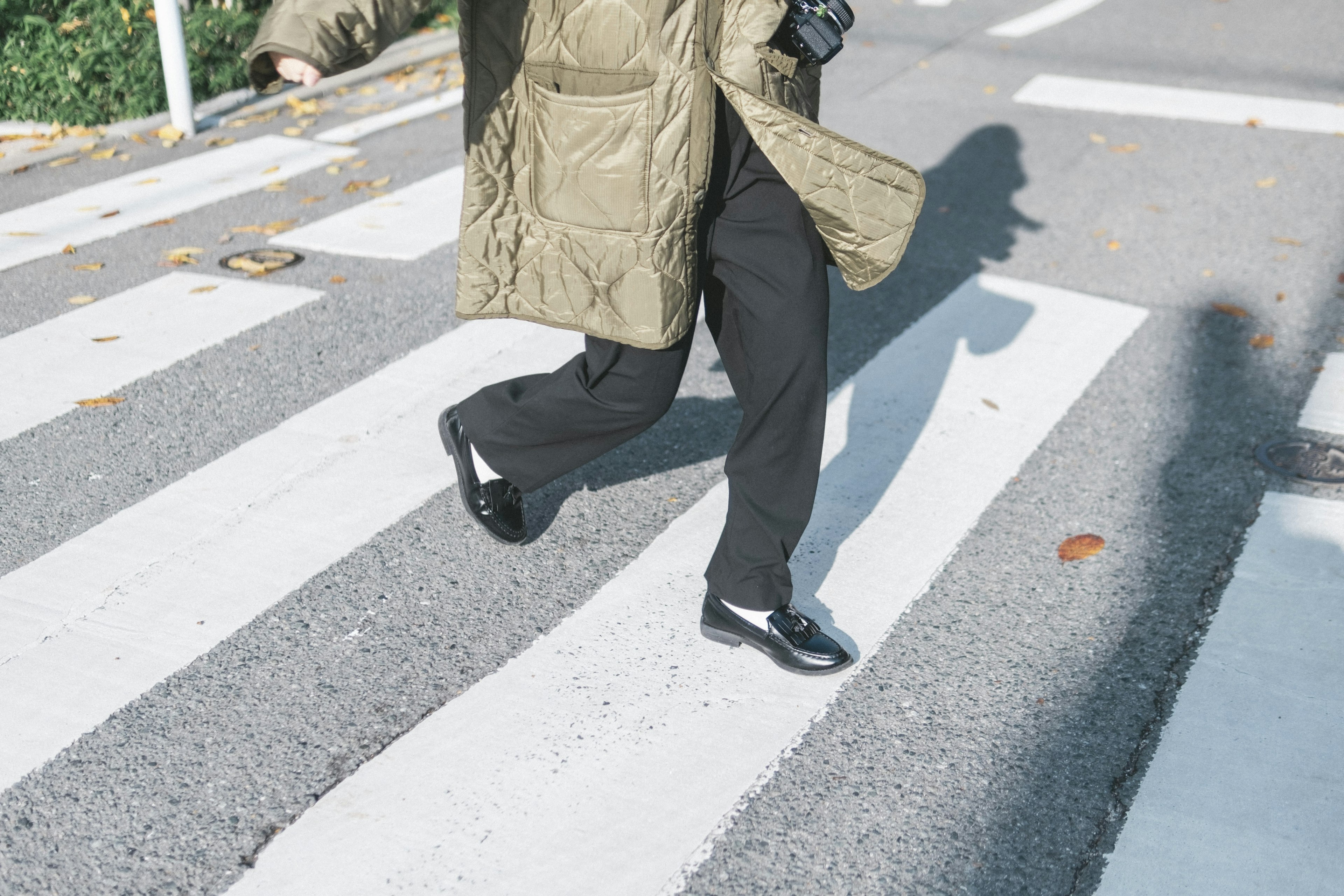 横断歩道を歩く人物の足元と影