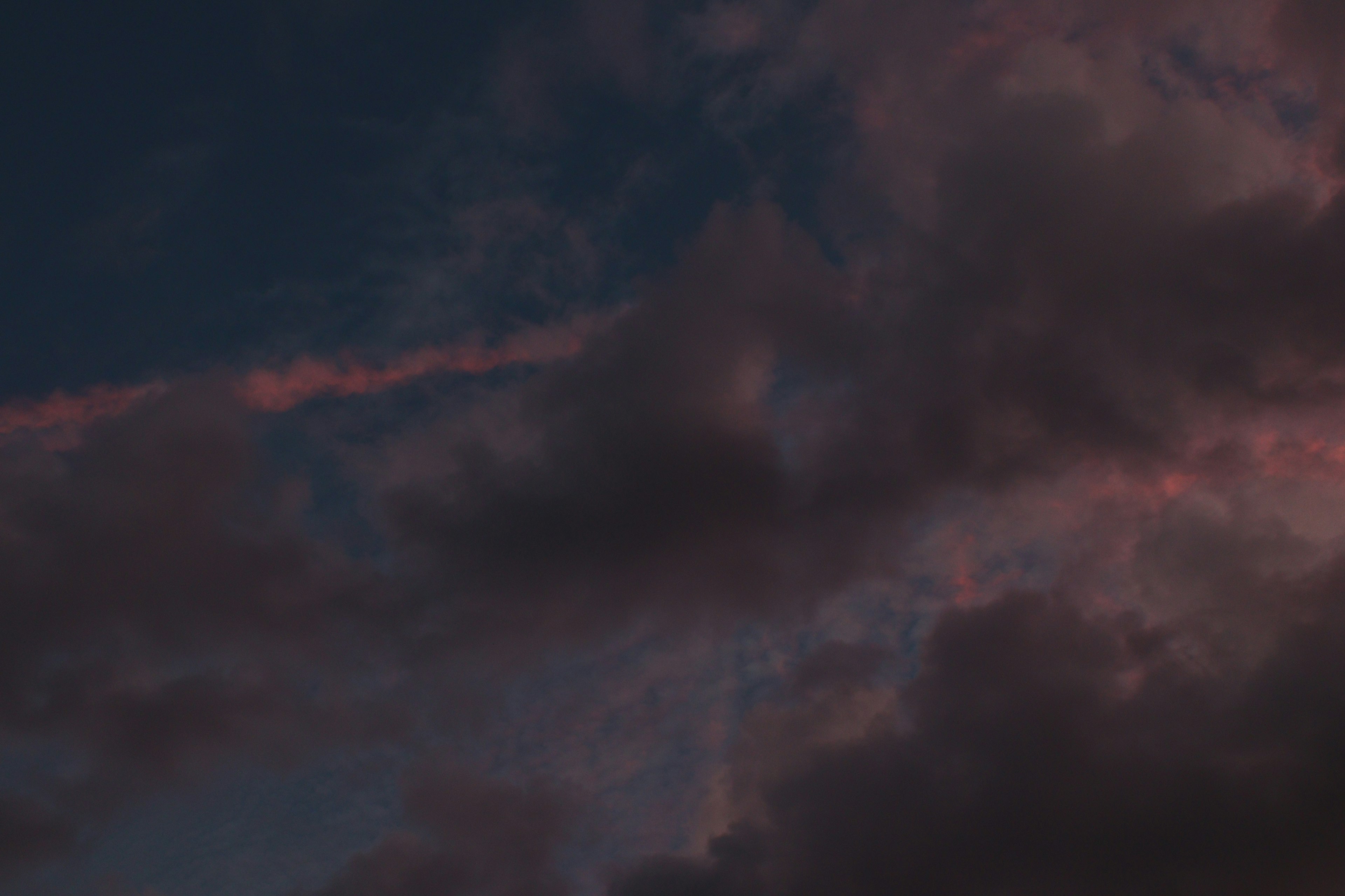 Cielo oscuro con nubes y matices tenues de atardecer