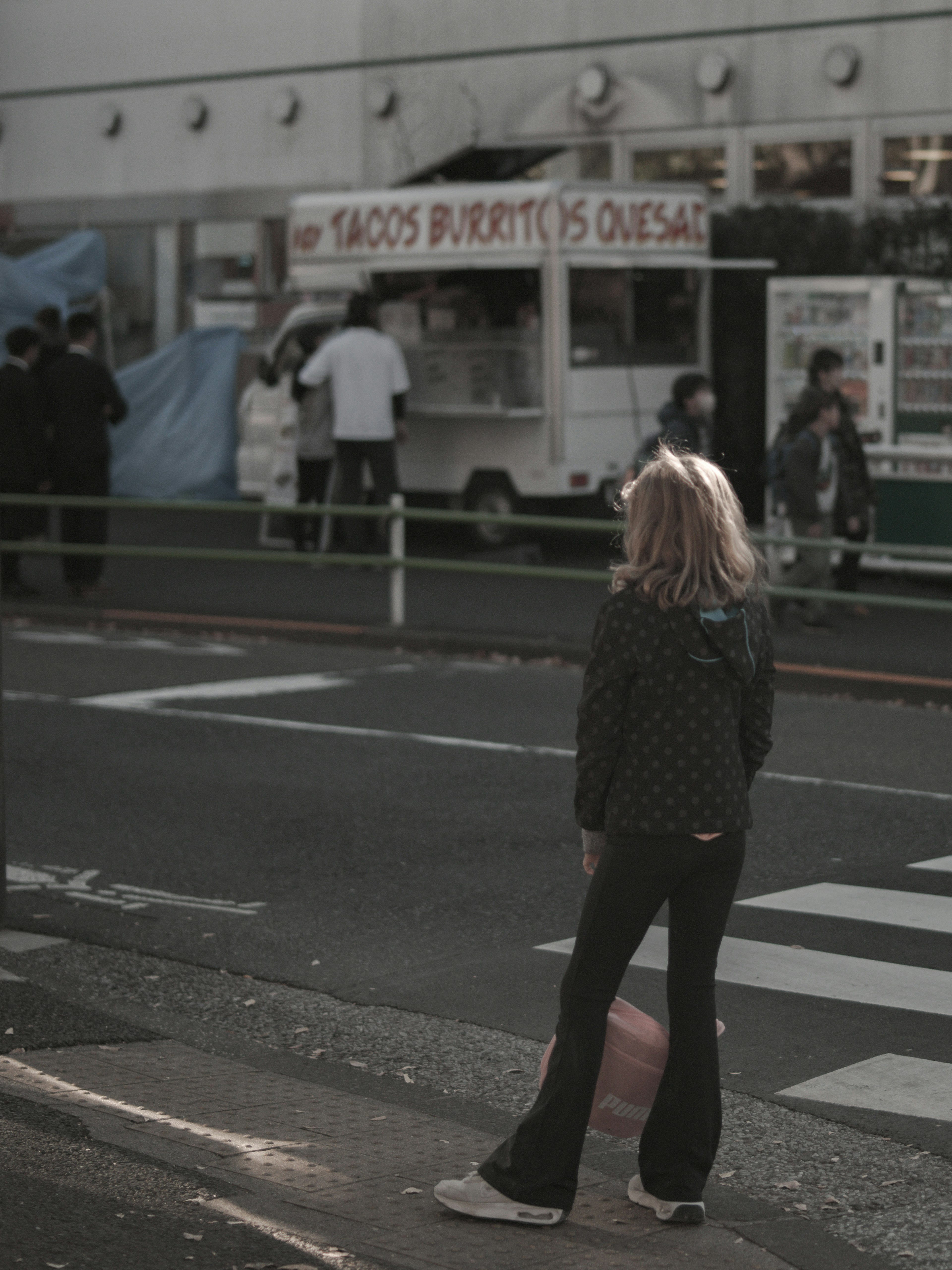 Una niña de pie frente a un camión de tacos