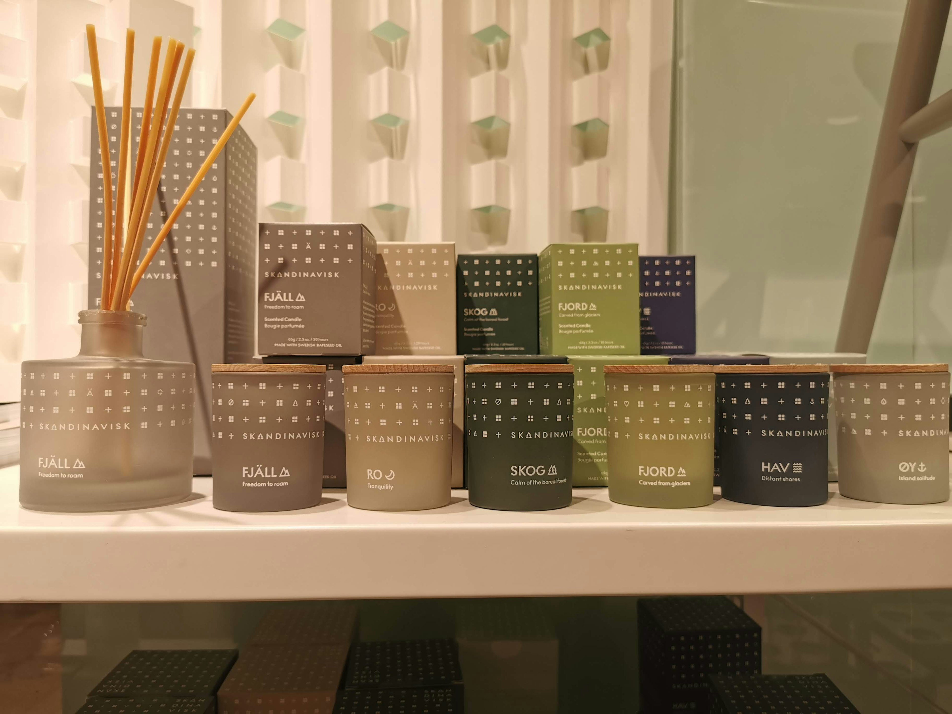 A display of scented diffusers and candles arranged on a shelf