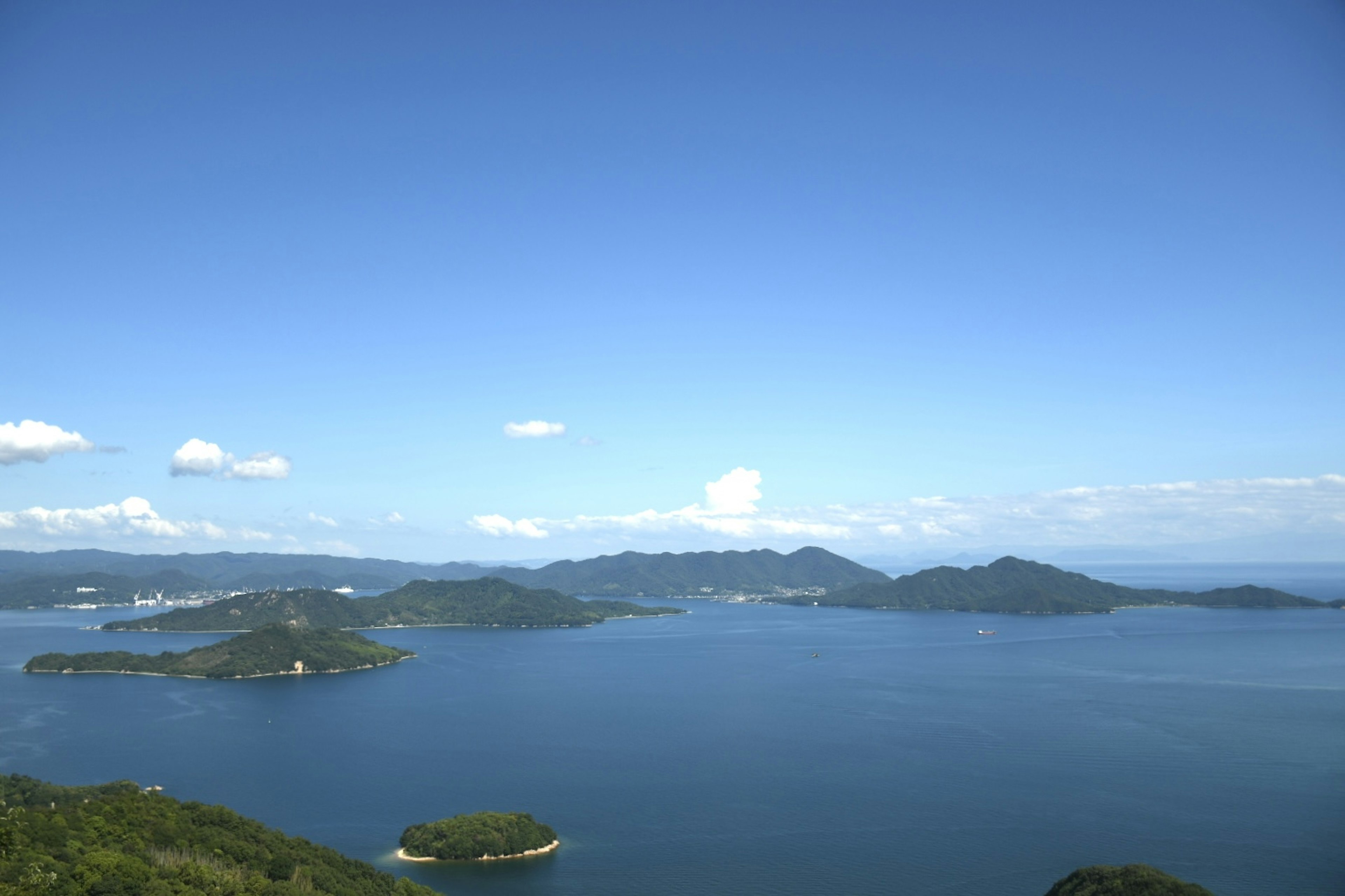 青い空と青い海に囲まれた小さな島々の風景